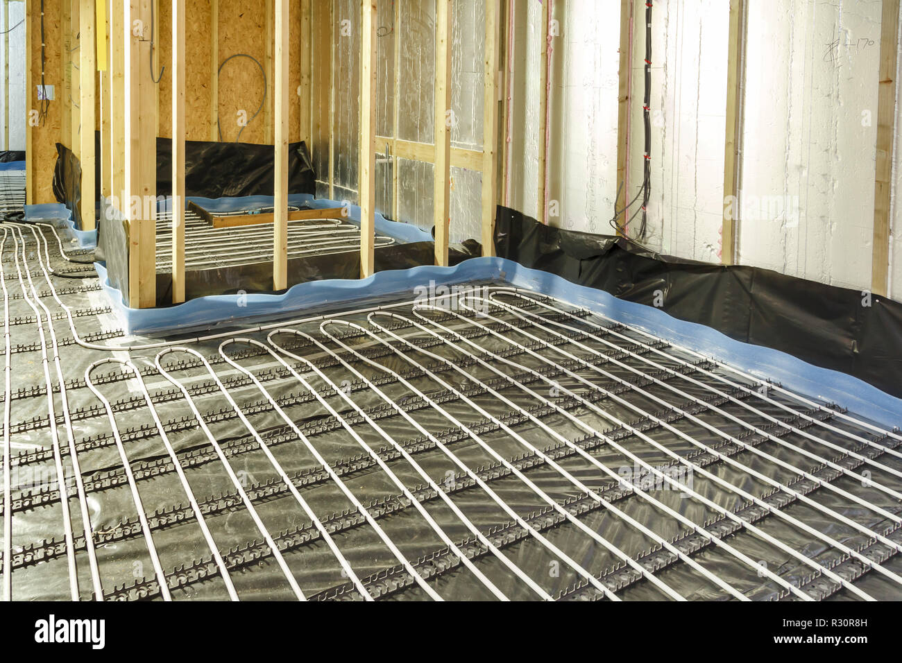 Casa in costruzione con riscaldamento a pavimento tubazioni di acqua di installazione per il sottofondo Foto Stock