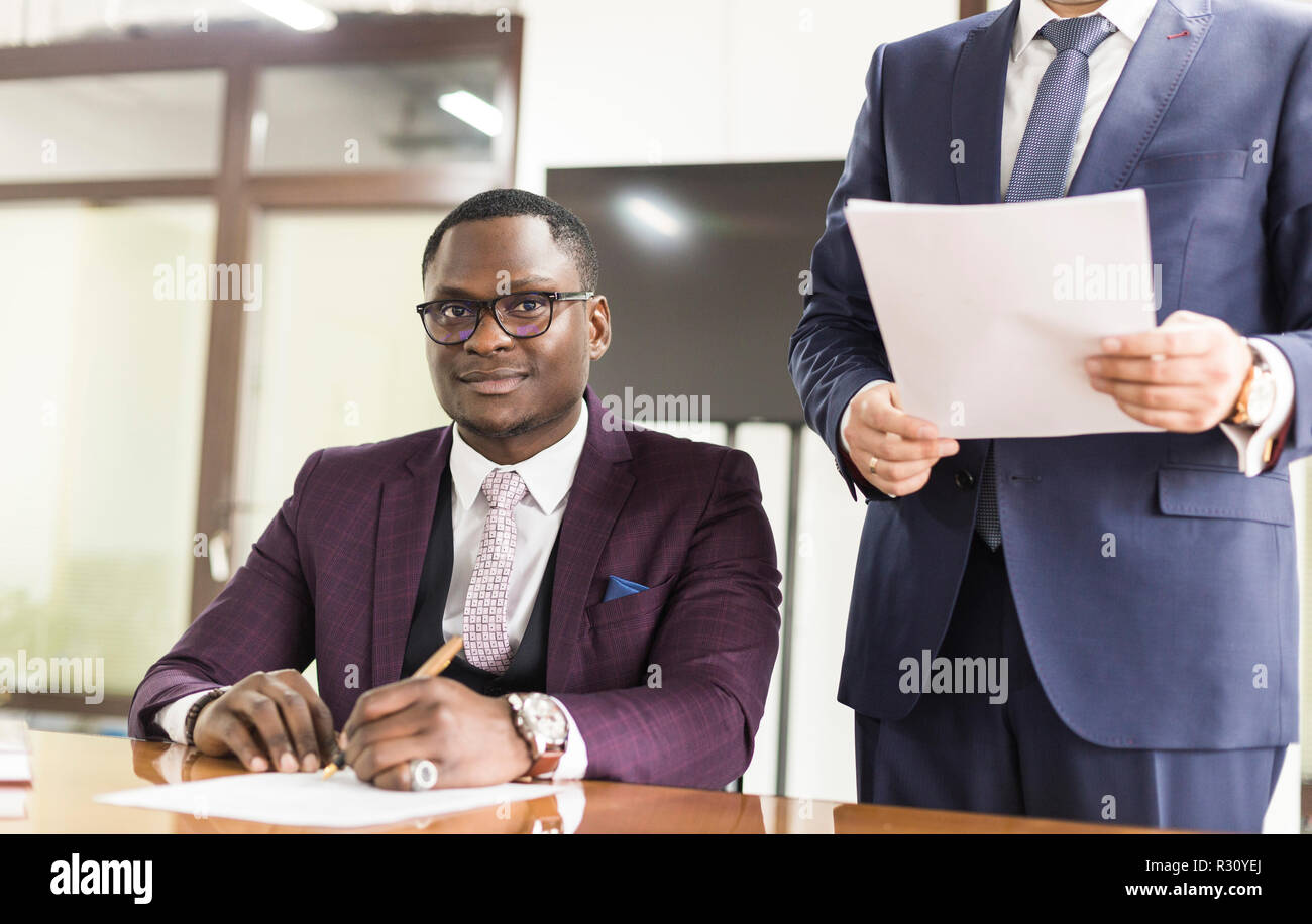 African American uomo firma contratto, uomo nero lato mettendo la firma sul documento ufficiale, biracial clienti clienti giovane effettuare acquisti o firmare Foto Stock
