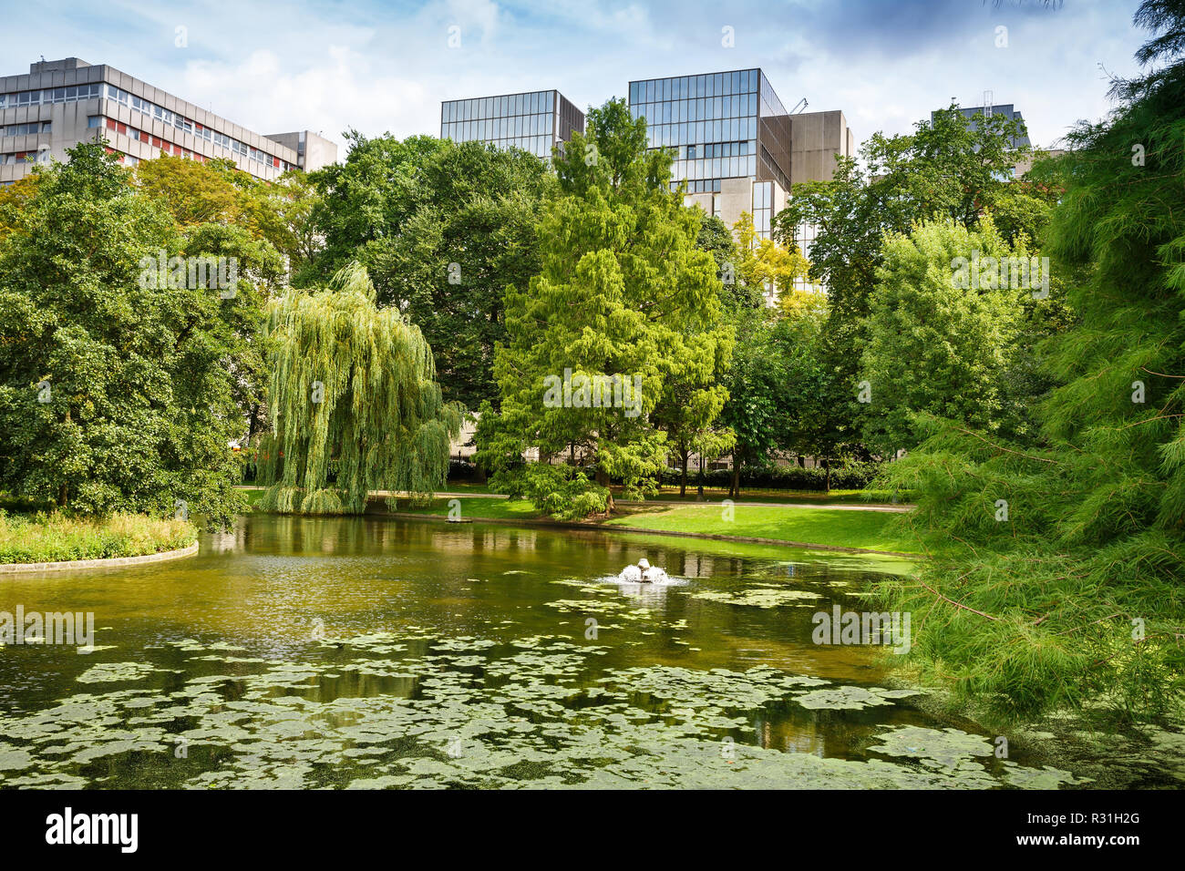 Parco Leopold con stagno, alberi ed edifici a Bruxelles, in Belgio. Foto Stock