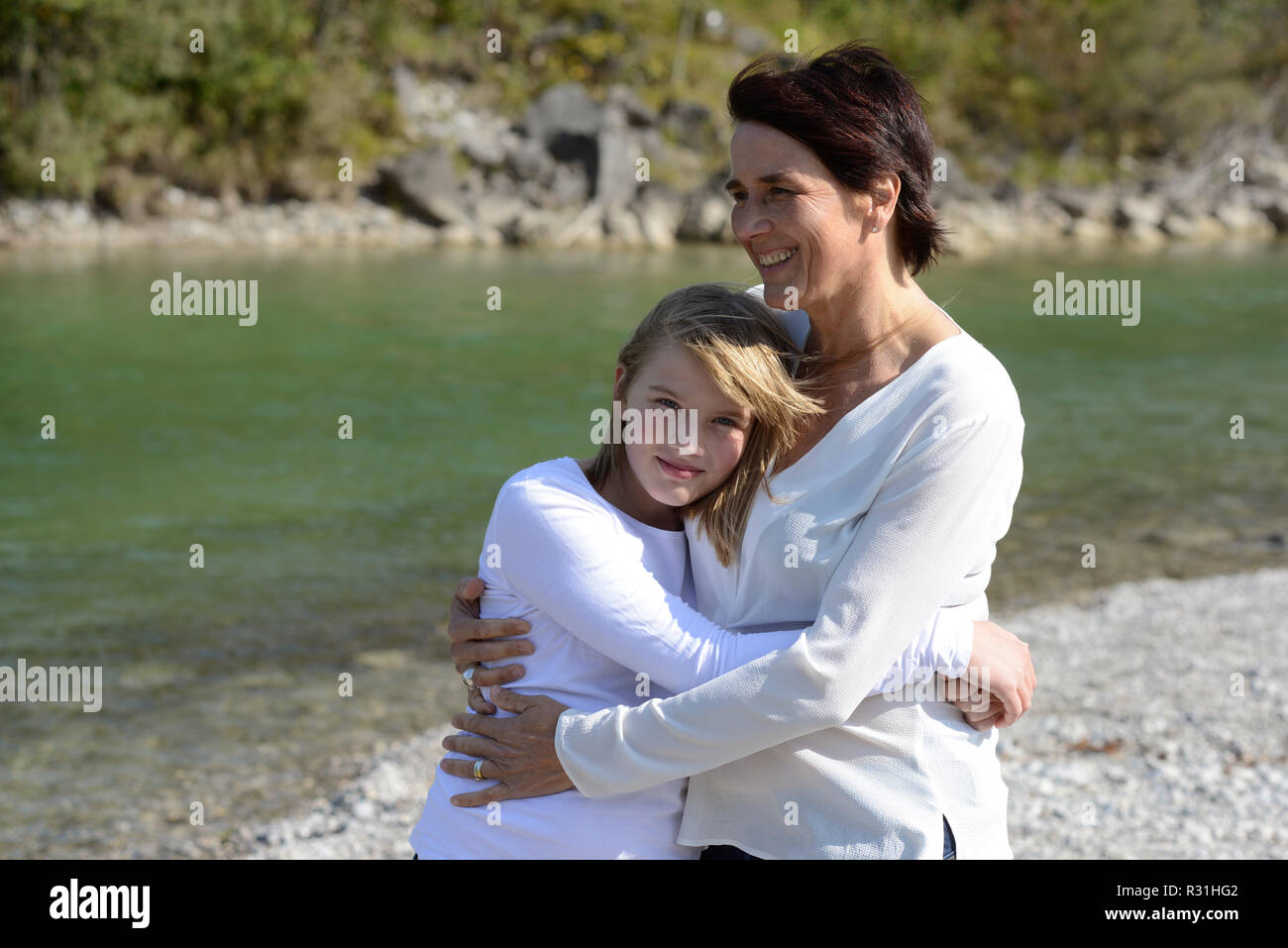 Ragazza abbraccia la sua madre ad un fiume e la felicità della famiglia, madre, familiarità Isarwinkel, Alta Baviera, Baviera, Germania Foto Stock