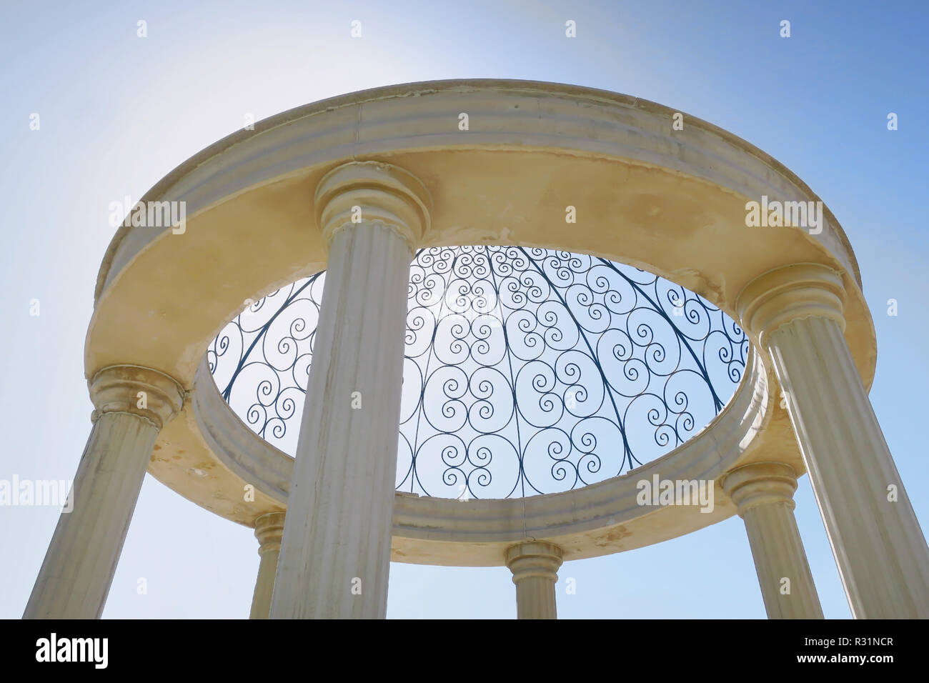 Un round, calcestruzzo decorativo con grandi pilastri su un luminoso cielo blu. Foto Stock