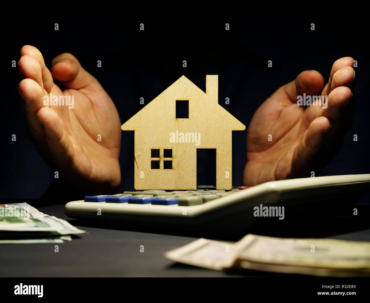 Modello di casa, calcolatrice e denaro. Prestito ipotecario per immobili. Foto Stock