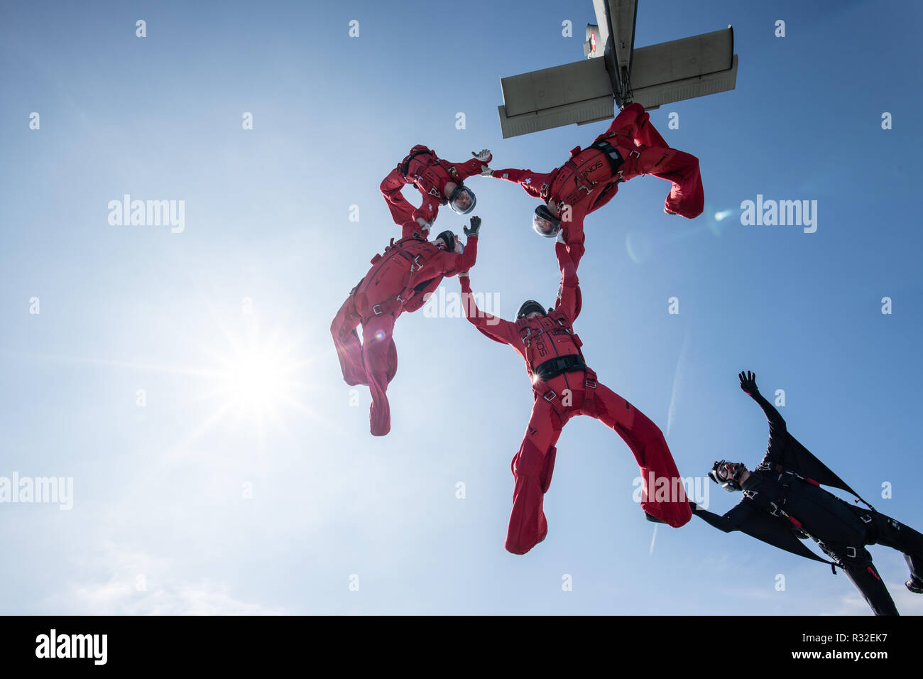 Swiss Team skydiving in uscita un militare Pilatus Porter aeromobili per la formazione di un salto con la loro cameraman Foto Stock