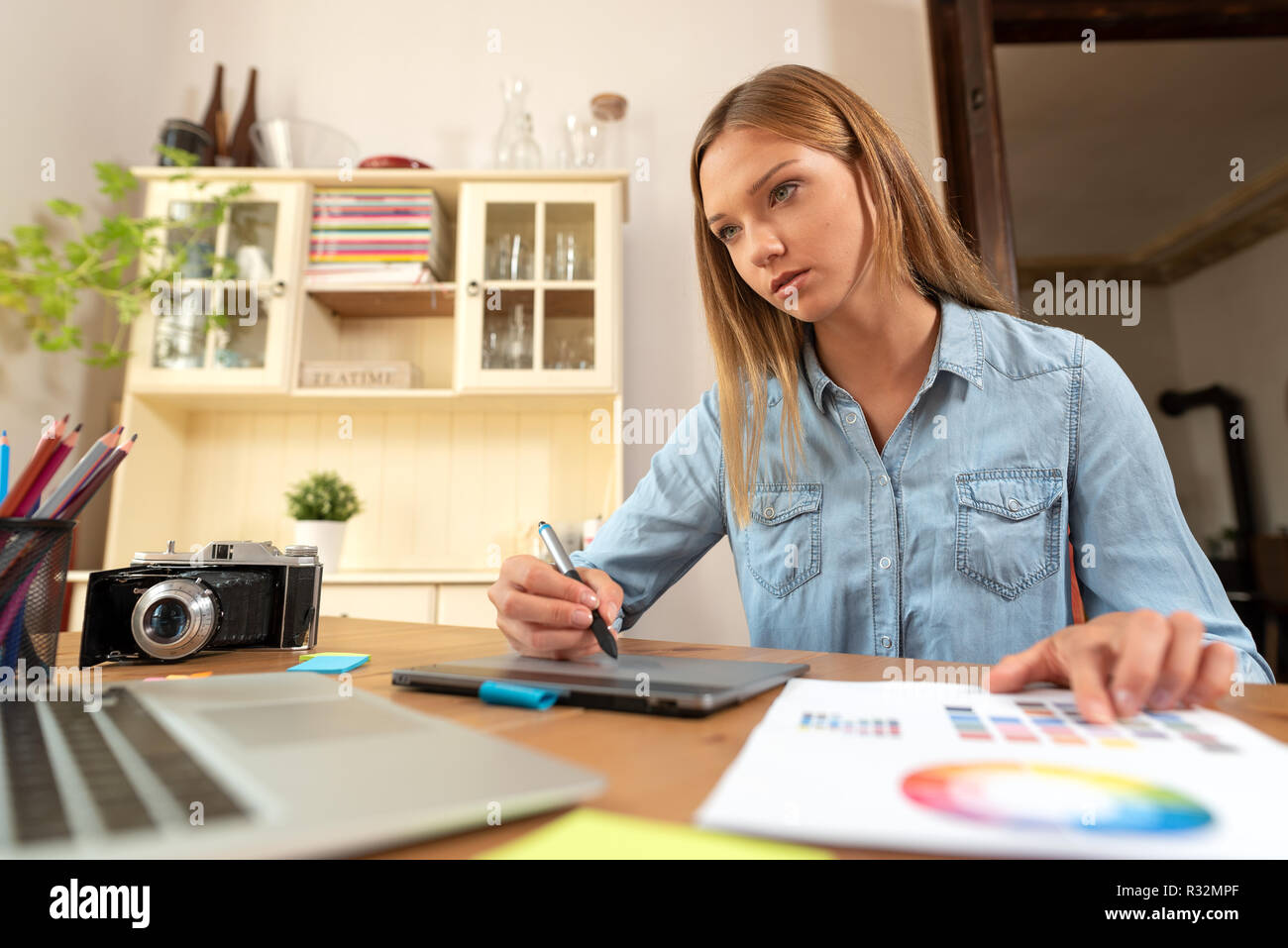 Donna artista grafico utilizza una tavoletta grafica, la progettazione e il disegno al computer, lavorare a casa, libero professionista Foto Stock