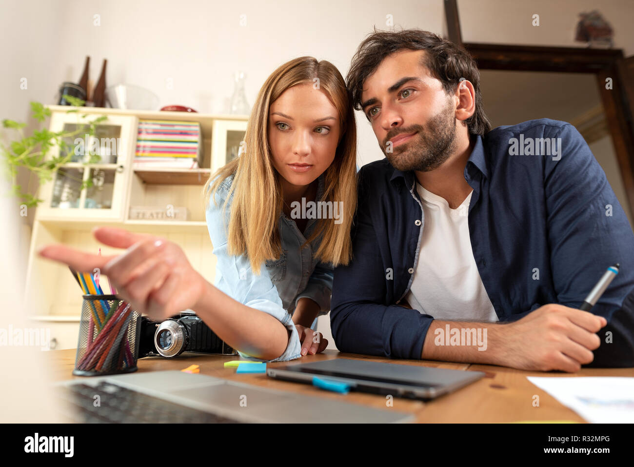 Graphic Designer parlare del progetto, la progettazione e il disegno al computer, lavorare a casa, freelancer il brainstorming Foto Stock