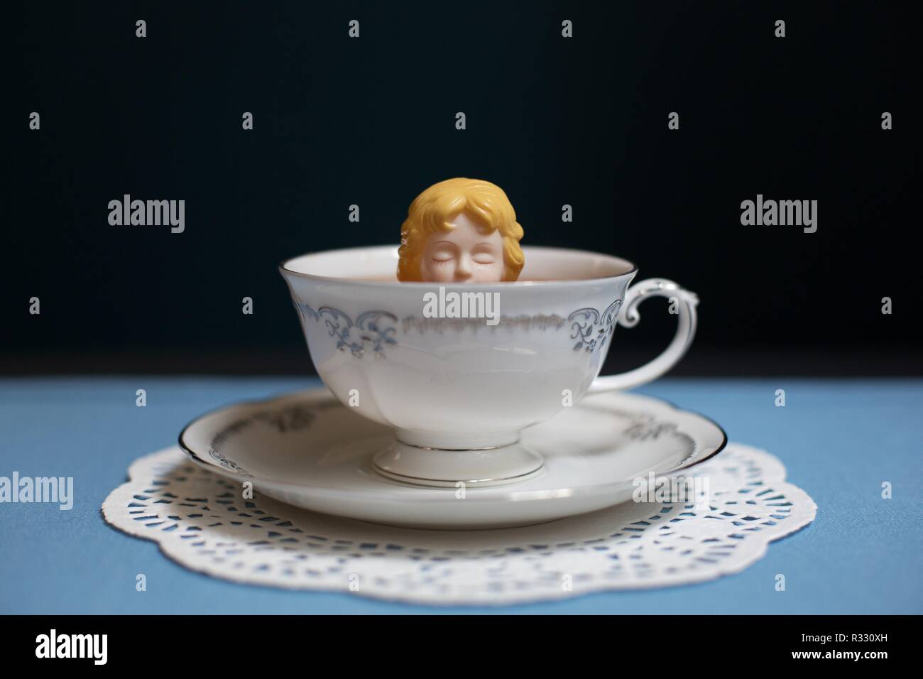 Surreale immagine di donna (doll) nella tazza da tè. Foto Stock