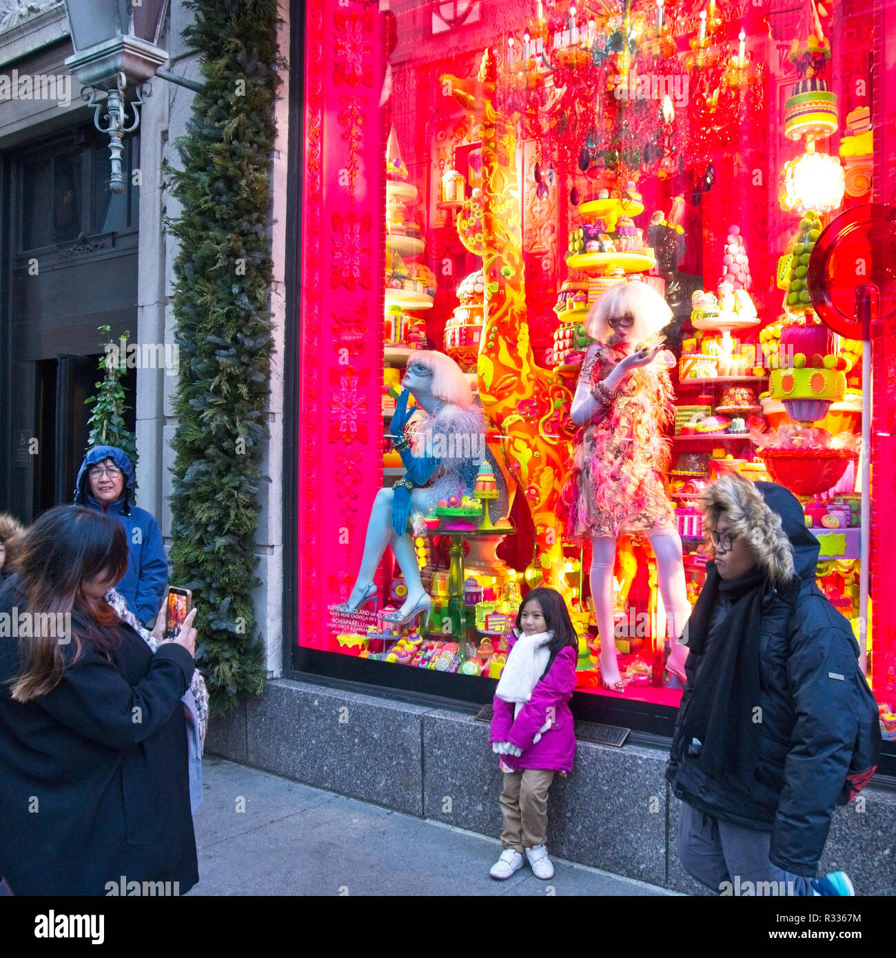 NEW YORK, USA, 20NOV2018. Una donna prende una foto delle sue figlie di fronte a una finestra di Bergdorf Goodman Luxury department store nel centro di Manhattan Foto Stock