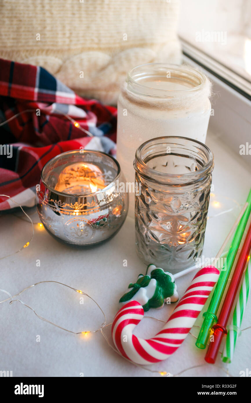 Ancora i dettagli di vita con candele, toy candy cane e la ghirlanda. Scandinavian hygge concetto, Natale e Anno Nuovo ferma la vita Foto Stock