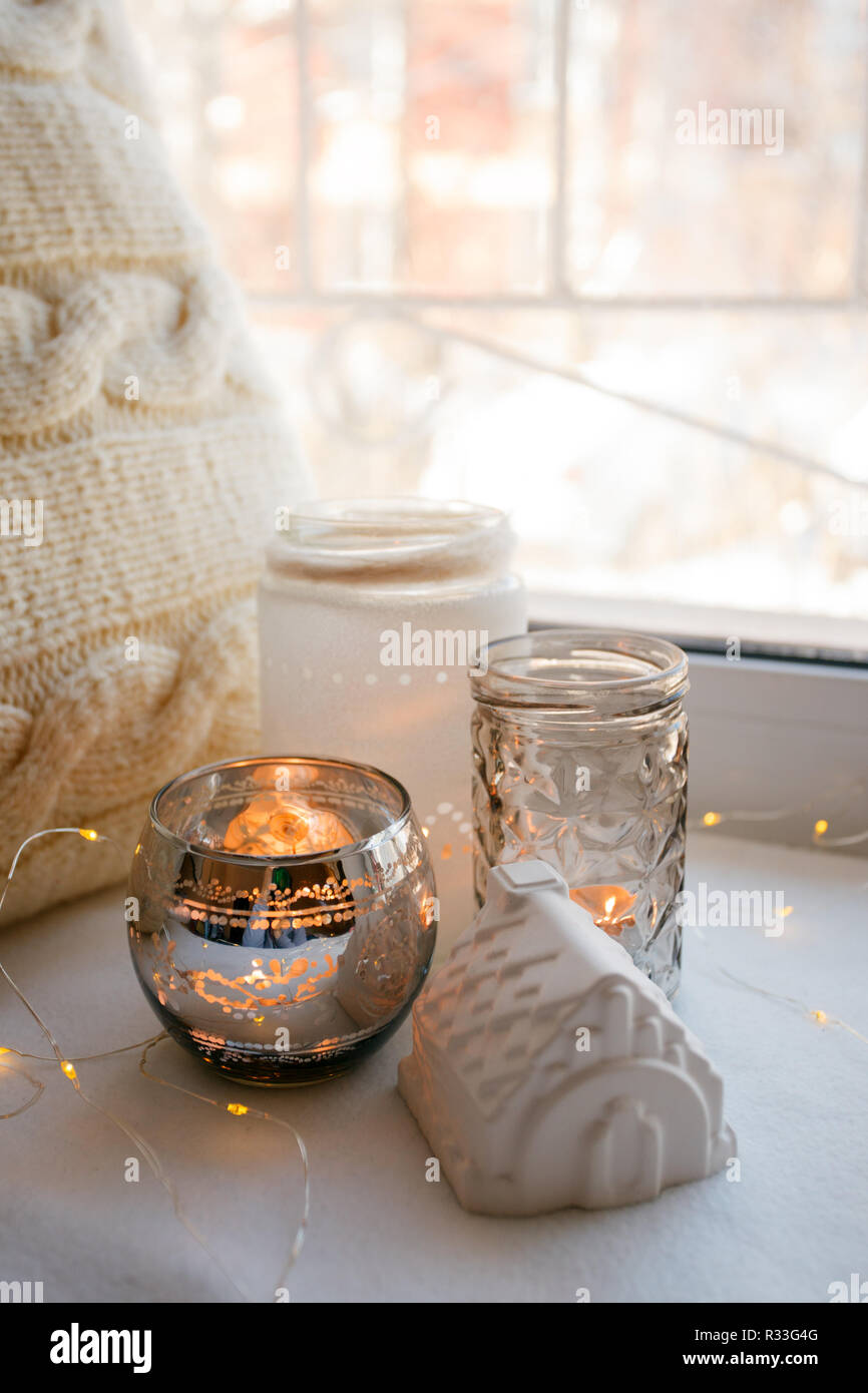 Ancora i dettagli di vita con candele, toy house e la ghirlanda. Scandinavian hygge concetto, monocromatico, stile kinfolk Foto Stock