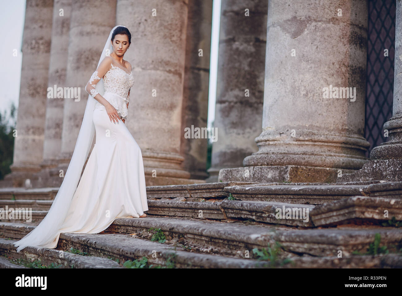 Sposa in un abito bianco in piedi su per le scale Foto Stock