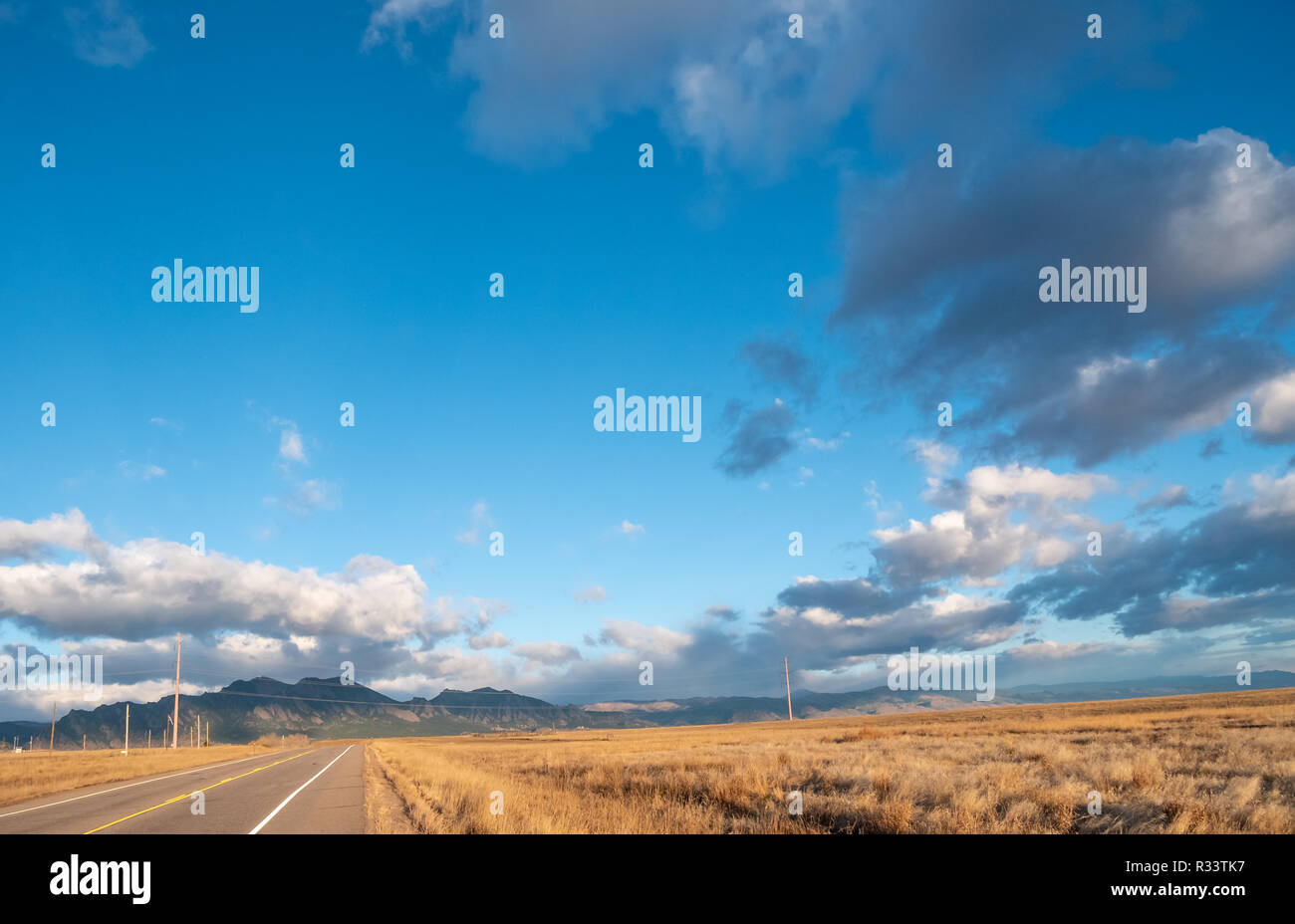 Corsia di una strada che conduce alla montagna con prevalenza di cielo sereno Foto Stock