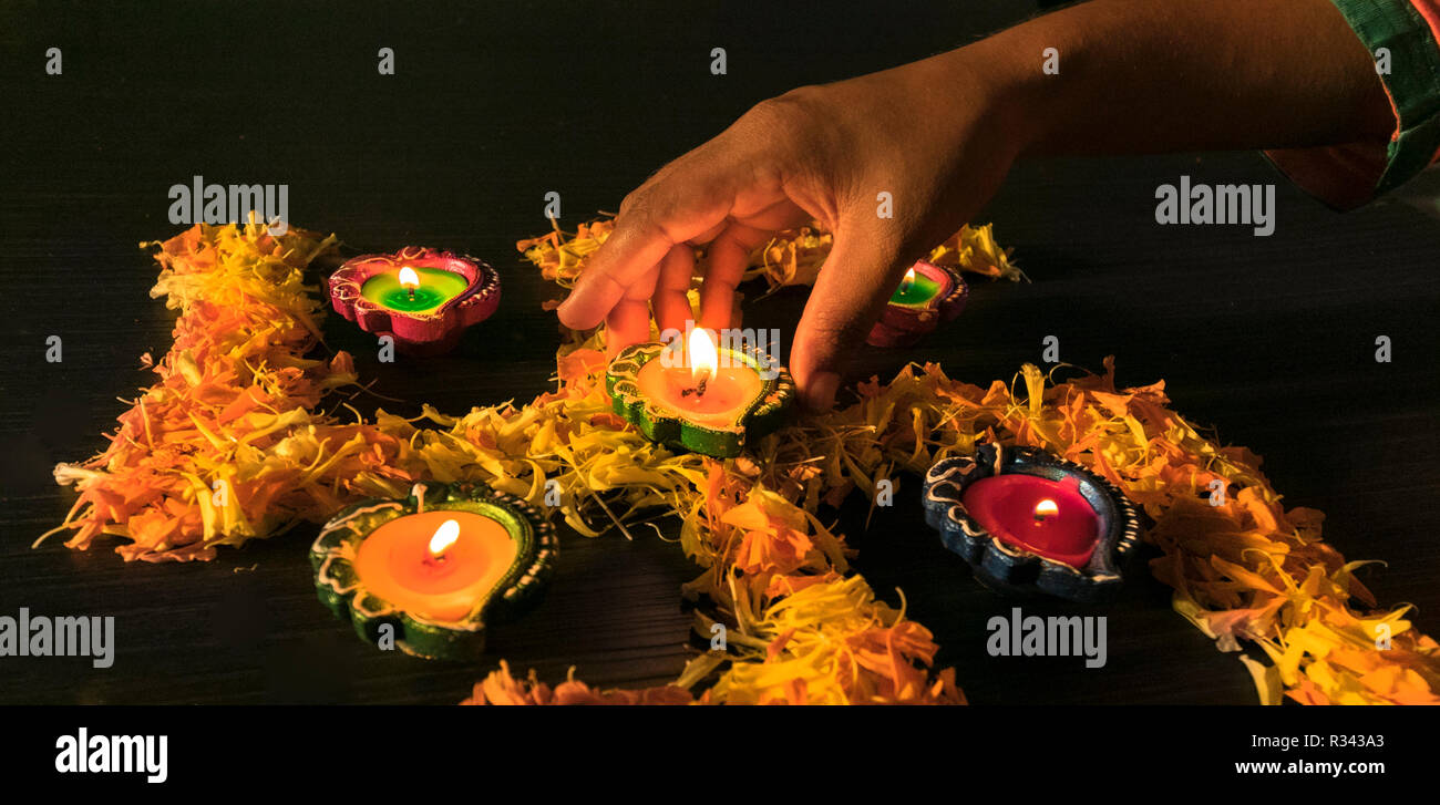 Una ragazza diyas illuminazione per celebrare diwali e dhanteras festival in India Foto Stock