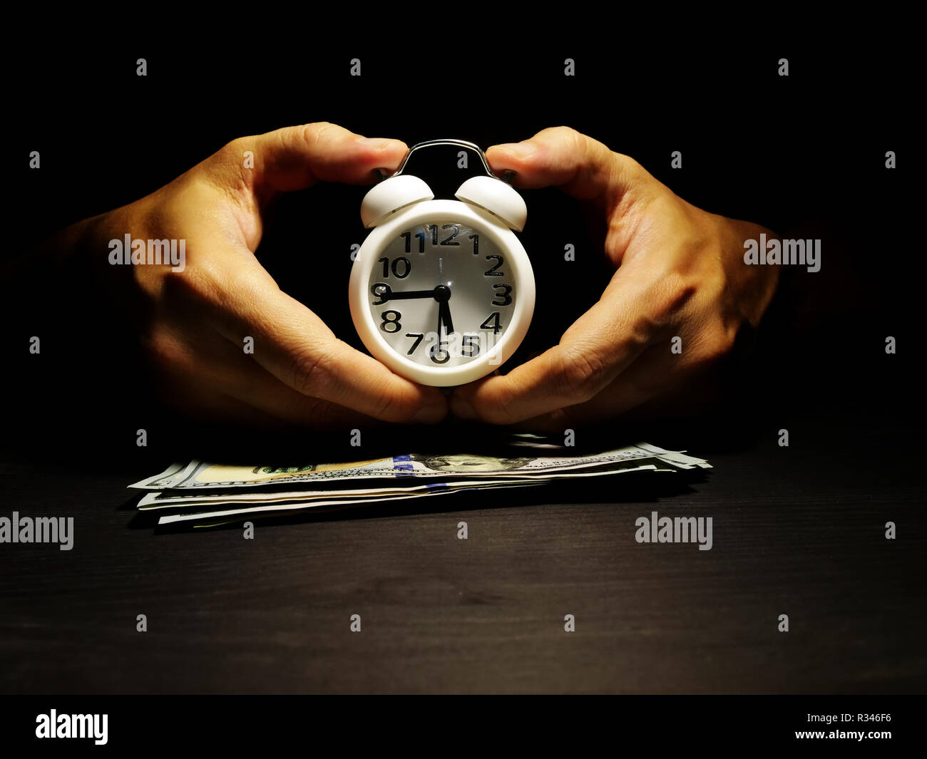 Mani tenere premuto il tasto alarm clock. Il tempo è denaro concetto. Foto Stock
