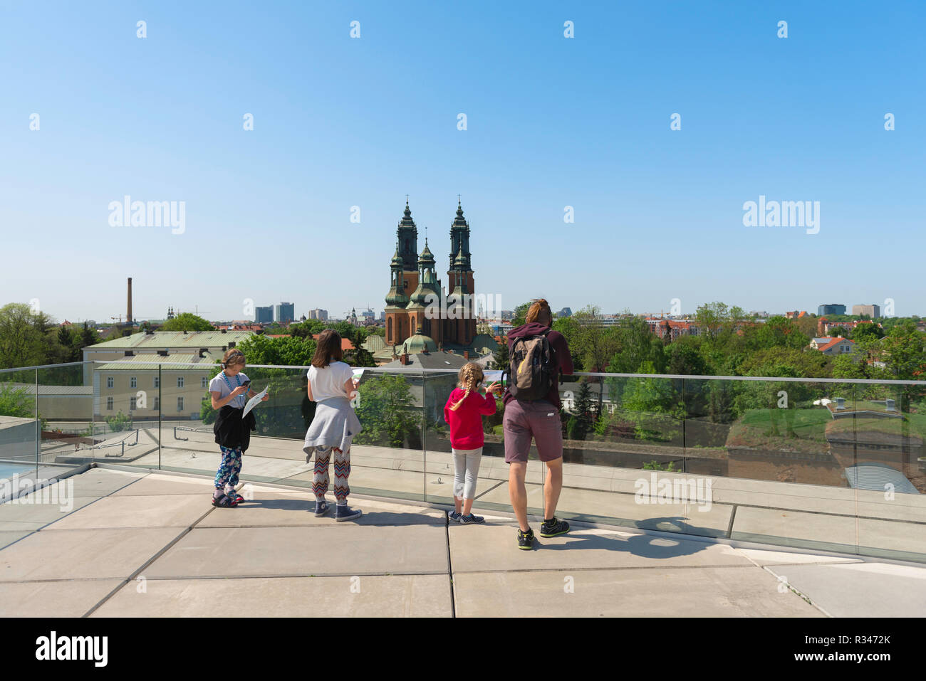 Porta Posnania Poznan, in vista di un gruppo di famiglia in piedi sul tetto del Poznan Interactive Heritage Centre guardando verso la Cattedrale Isola, Polonia. Foto Stock