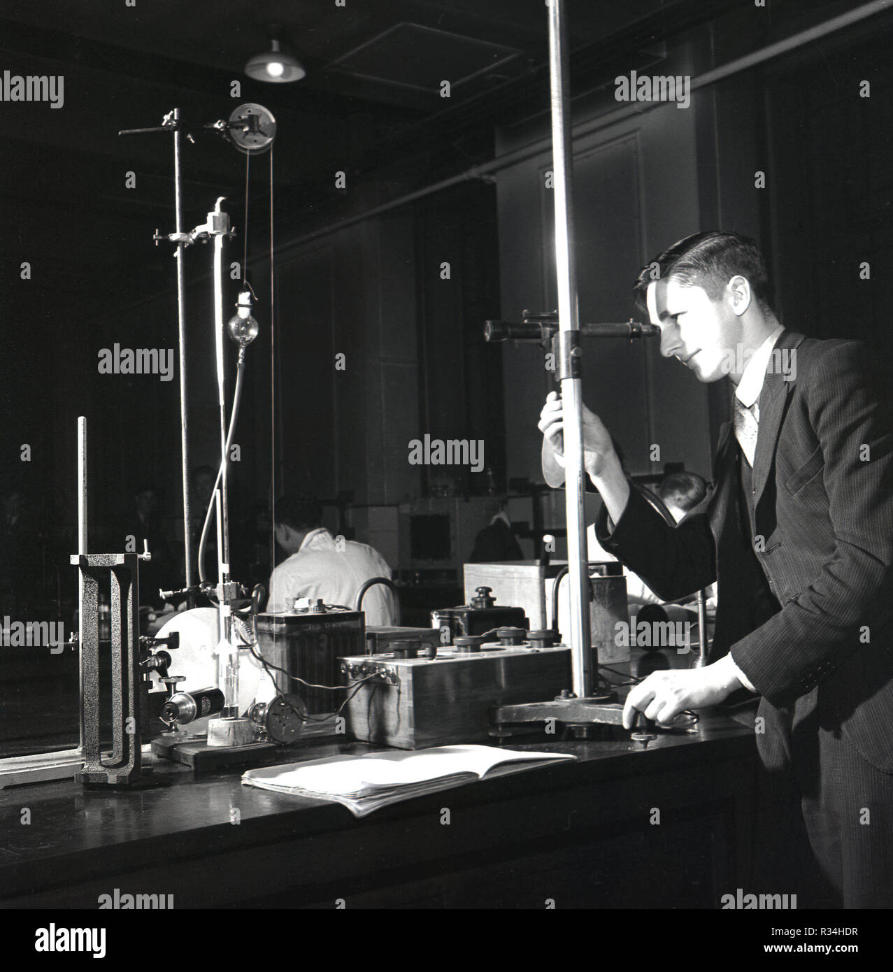 Degli anni Cinquanta, la ricerca presso università di Leeds, nel laboratorio di scienze, giovane in tuta labaoratory utilizzando attrezzature o apparecchiatura del giorno per fare esperimenti, Leeds, Inghilterra, Regno Unito. Foto Stock