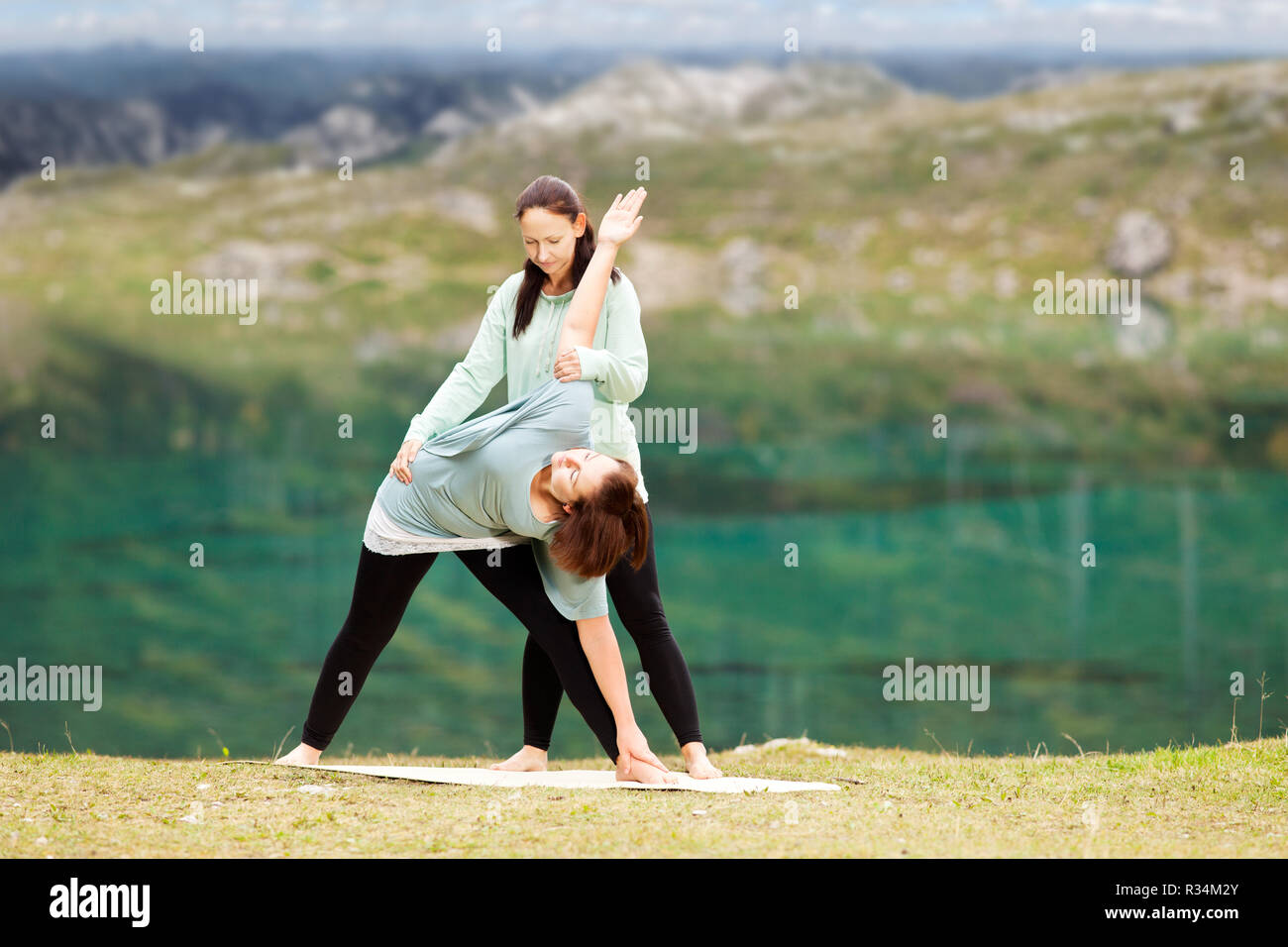 Femmina insegnante di yoga offre assistenza in materia di formazione Foto Stock