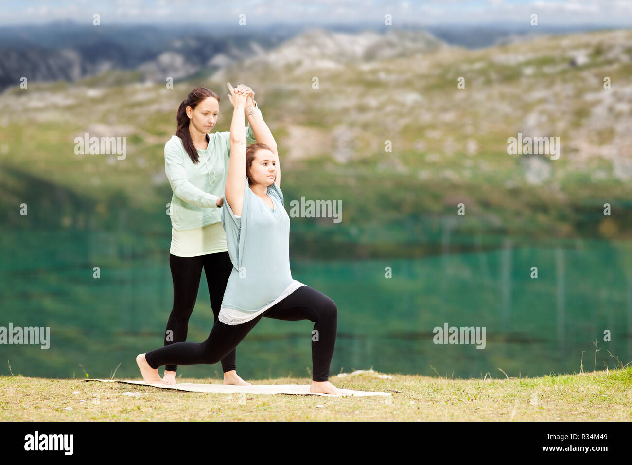 Femmina istruttore yoga fornisce assistenza in materia di formazione Foto Stock