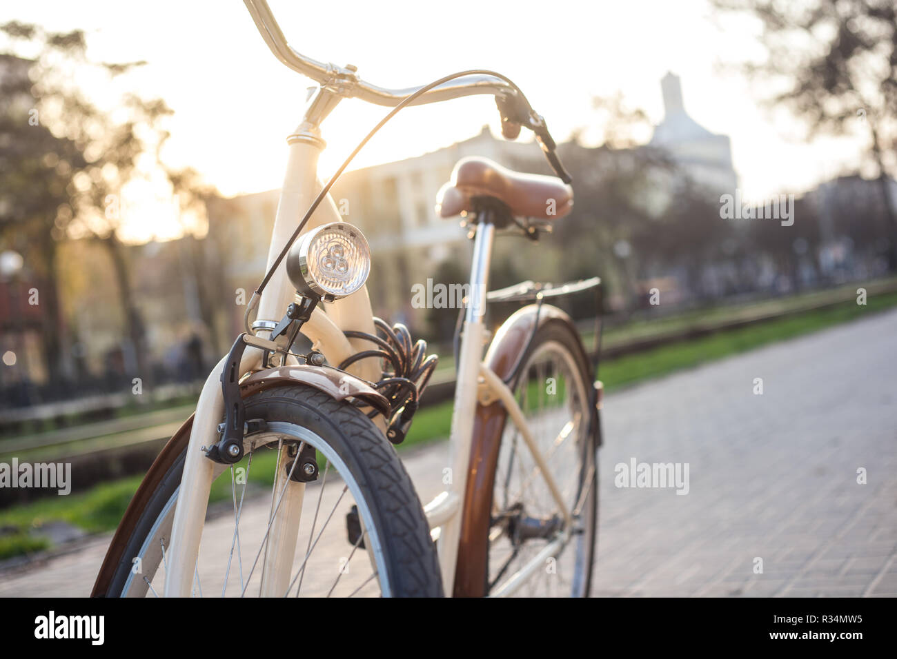 Bicicletta di colore beige con una lanterna sul vicolo in città in primavera Foto Stock