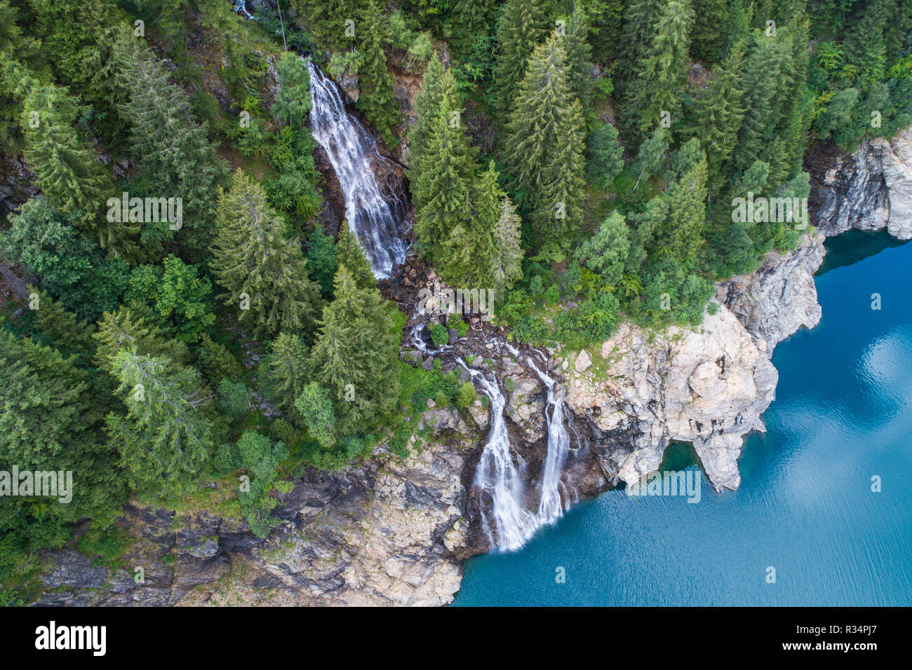 Cascata in una foresta e lago alpino. Foto aerea Foto Stock
