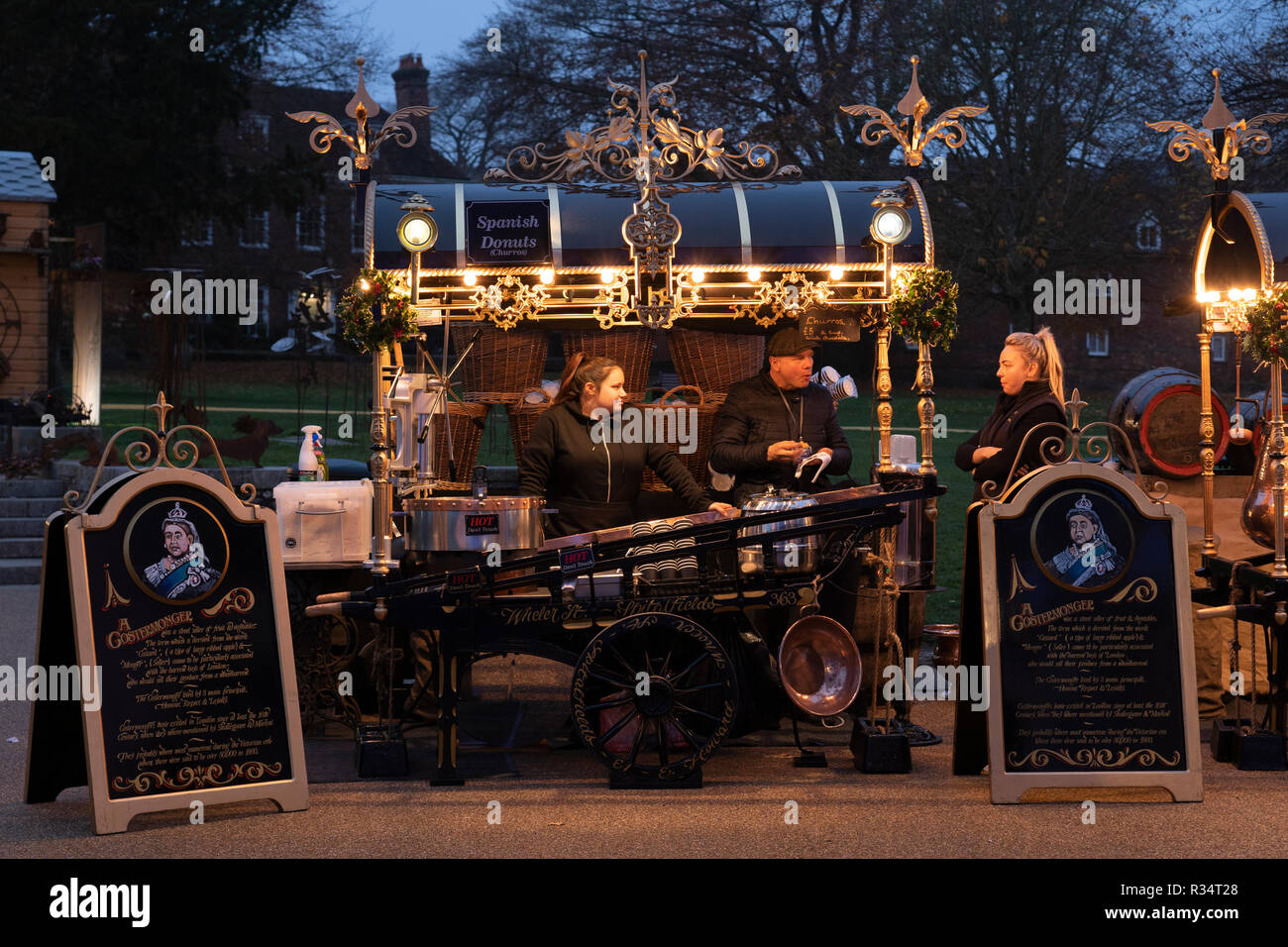 Una bancarella del mercato del costermonger che vende ciambelle spagnole (Churros) fuori della Cattedrale di Winchester a Natale. Inghilterra, Regno Unito Foto Stock