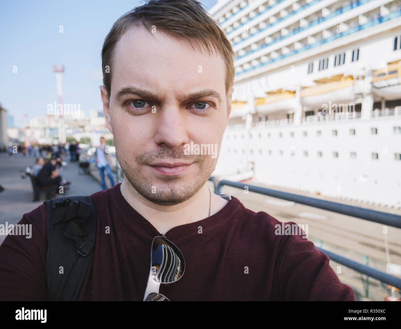 Giovane fa selfie vicino a una nave da crociera. Foto Stock