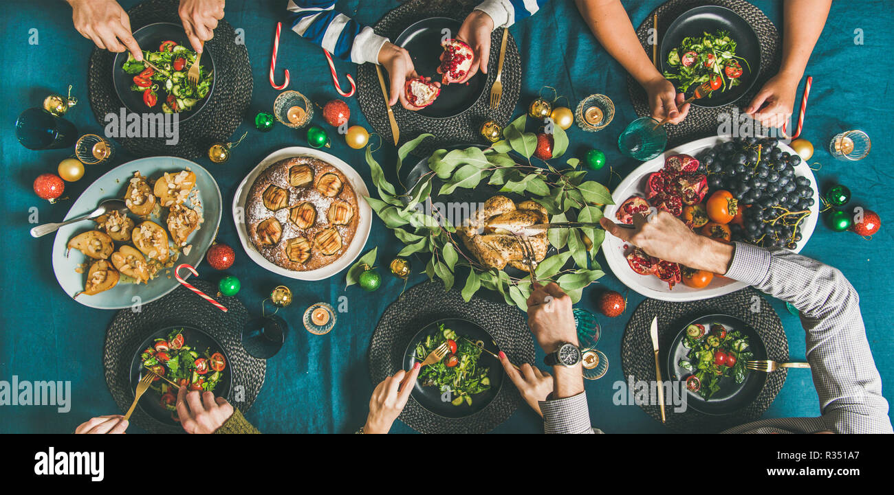 Le mani umane mangiare diversi pasti a Christmas party Foto Stock