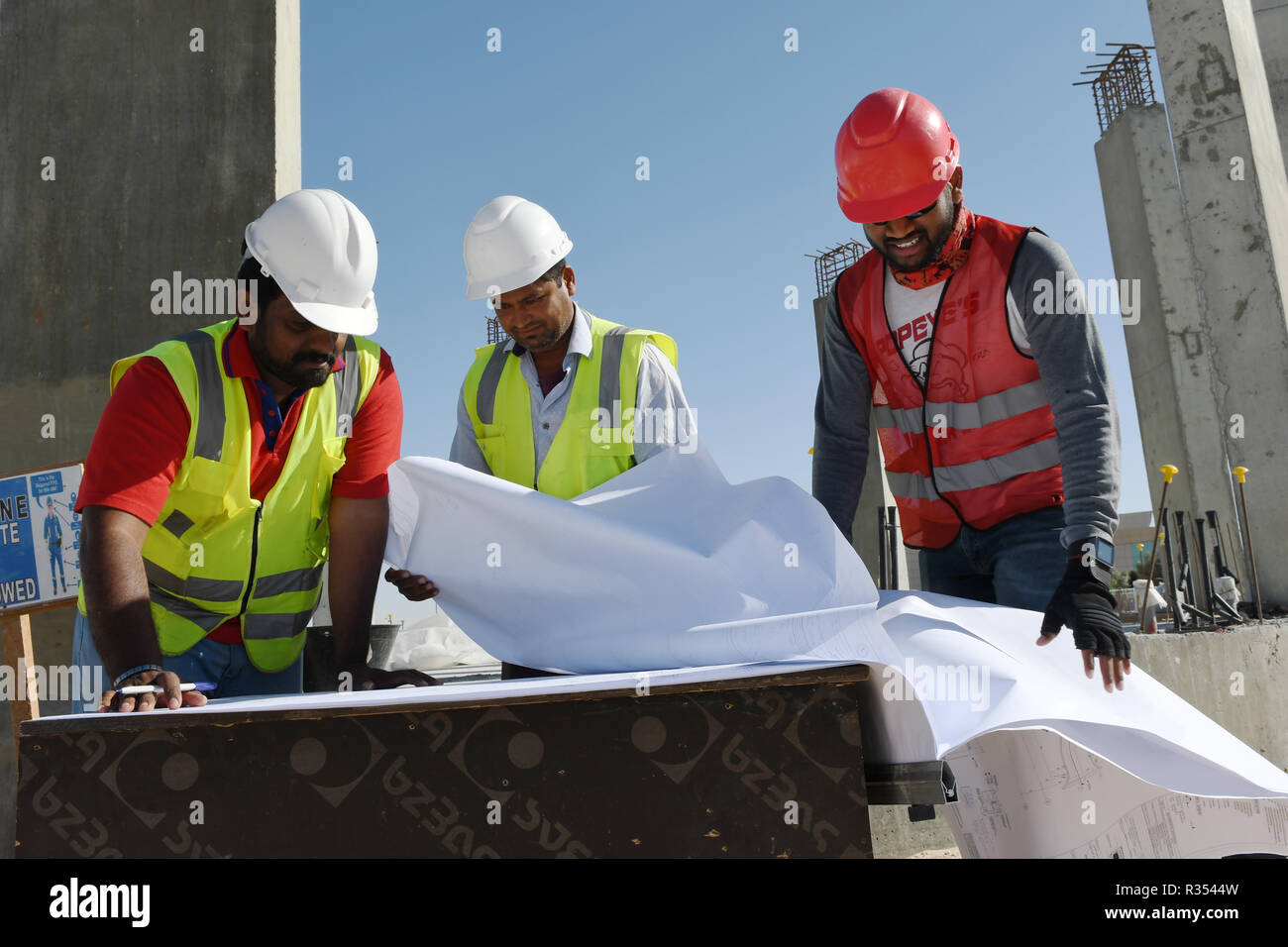 Gli uomini al lavoro nel settore della costruzione per lavorare in esterno nel sole caldo sotto il cielo ro sostenere le loro famiglie. Foto Stock