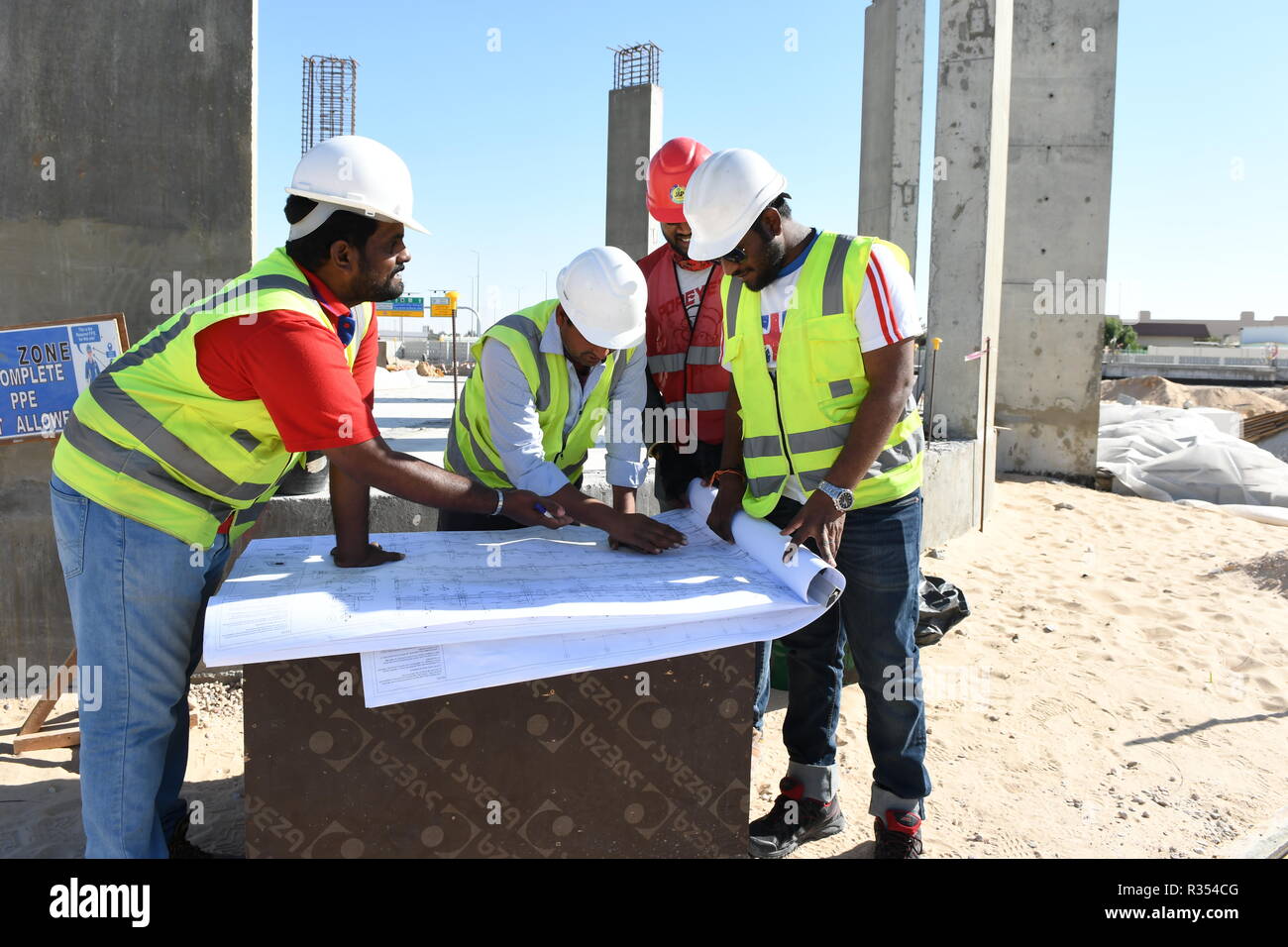 Gli uomini al lavoro nel settore della costruzione per lavorare in esterno nel sole caldo sotto il cielo ro sostenere le loro famiglie. Foto Stock