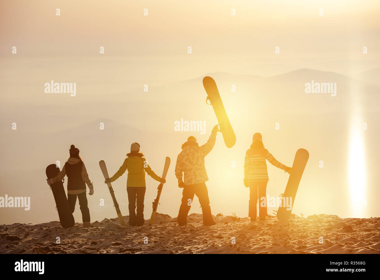 Gruppo di sciatori e snowboarder al tramonto. Ski resort concept Foto Stock