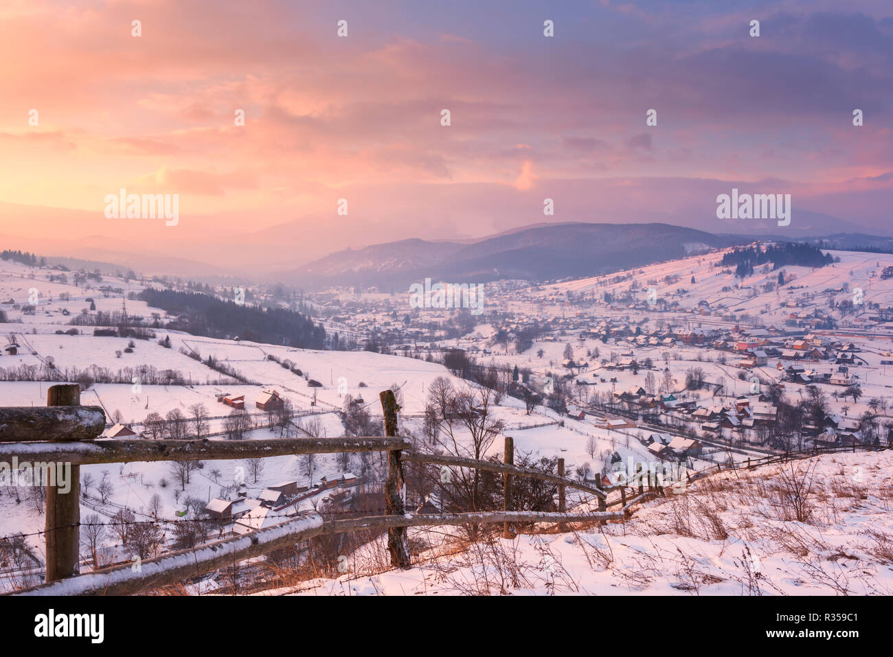 Incantevole paesaggio invernale in morbida luce del tramonto, valle alpina circondata da montagne ricche di boschi, nei Carpazi Foto Stock