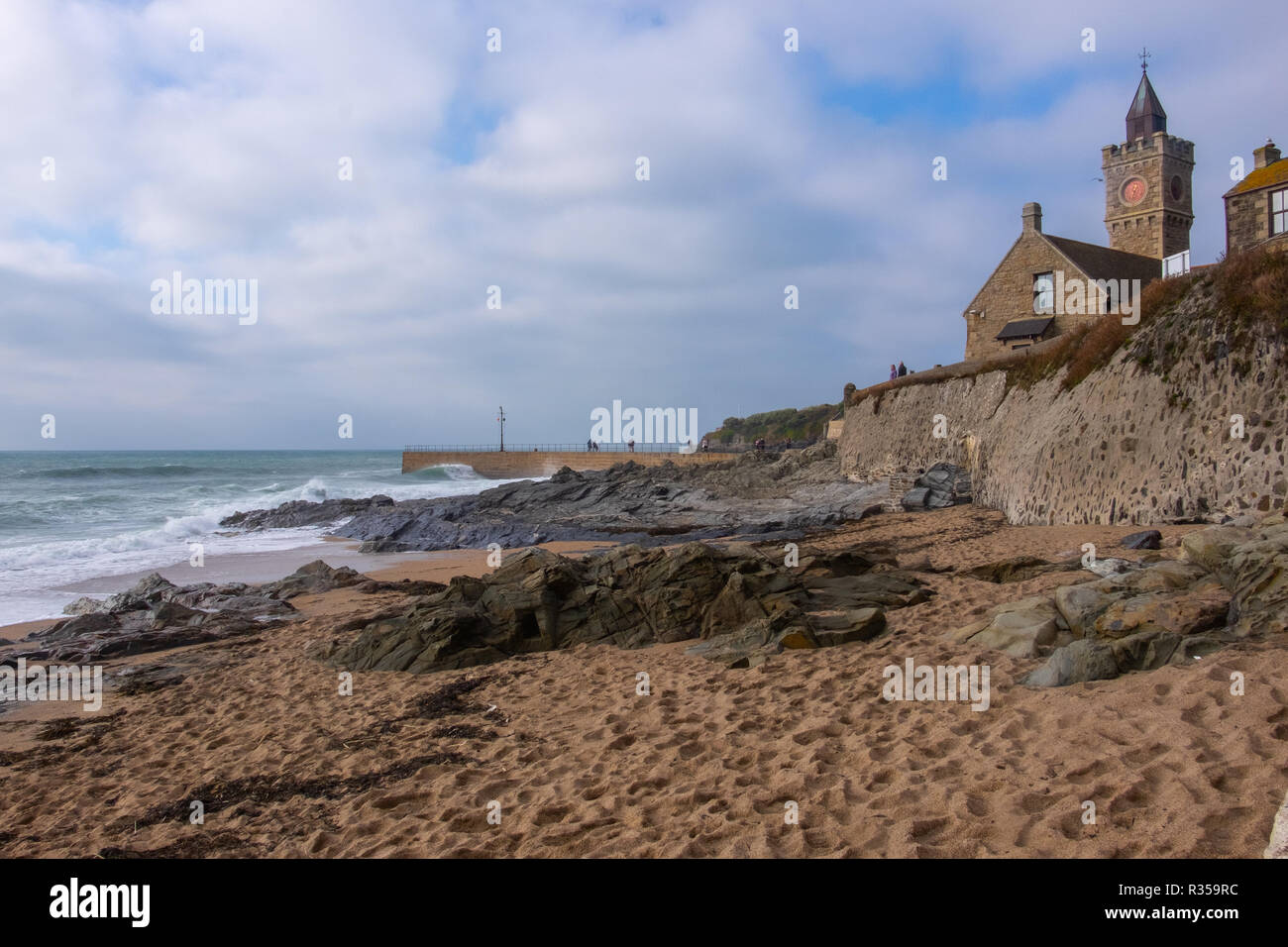 Visualizzare fino verso Porthleven Chiesa che si trova proprio sopra la spiaggia e il mare. Come si vede dalla spiaggia e rocce al di sotto del vento e sole. Foto Stock