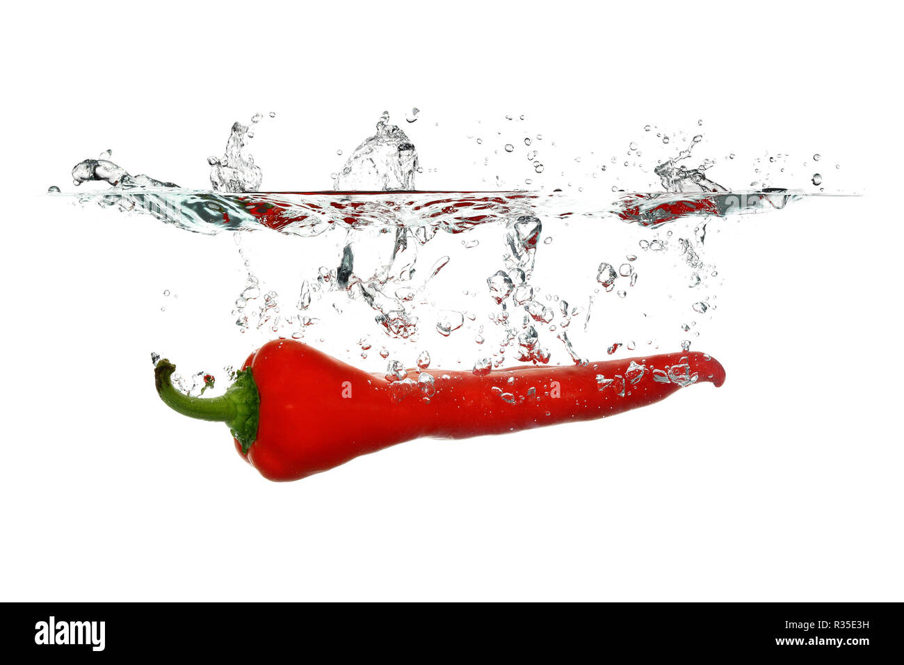 Peperone rosso è sceso in acqua isolati su sfondo bianco Foto Stock