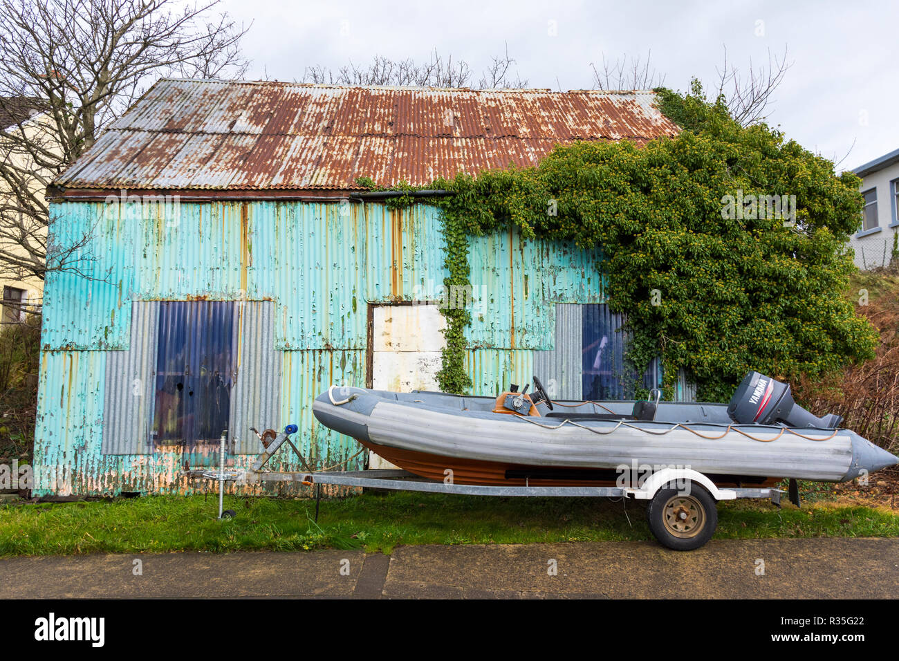 Burtonport, vecchio ferro corrugato sparso e la nervatura di barca in County Donegal, Irlanda Foto Stock