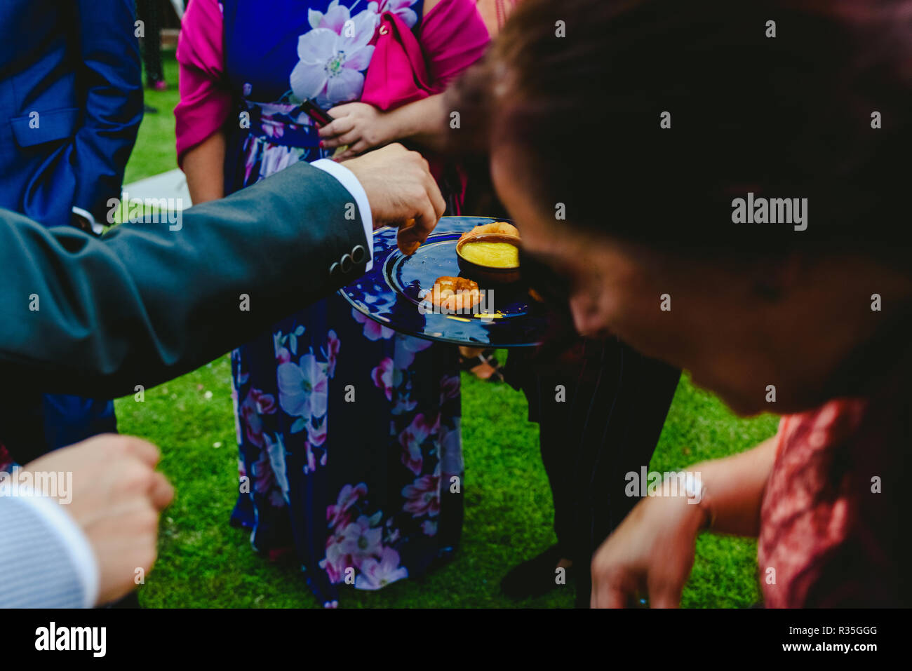 I camerieri che offre spuntini per le persone che li cattura con le loro mani in corrispondenza di un evento sociale Foto Stock