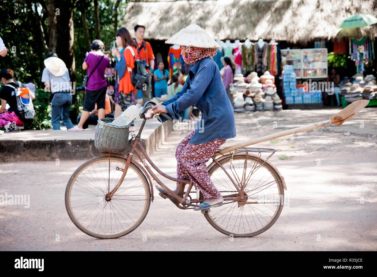 Angkor Wat, Cambogia - 30 ottobre 2011:cambogiani donna in bicicletta attraverso un villaggio. Foto Stock