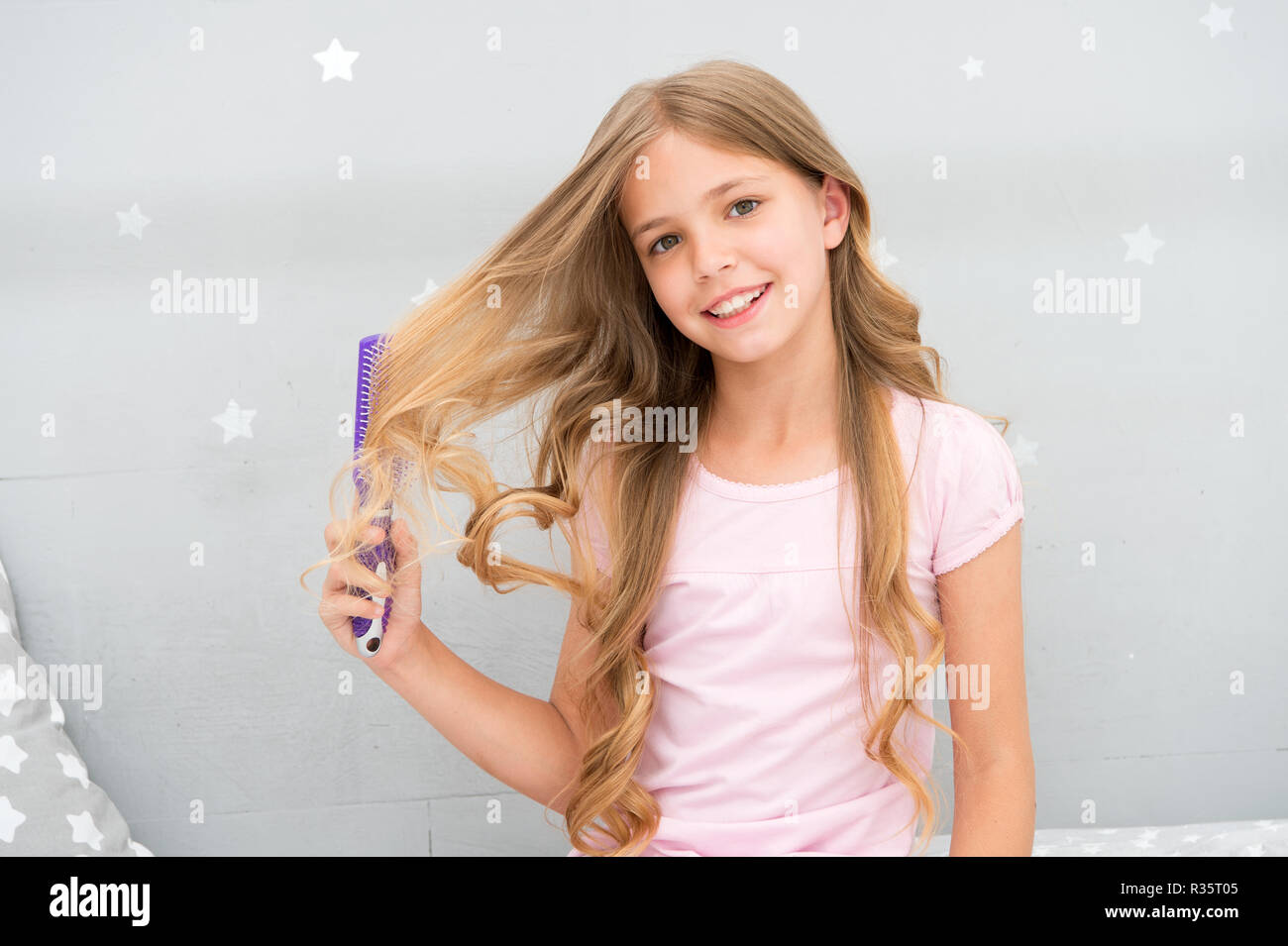 Bambino curly hairstyle tenere spazzola o pettine. Pettine per capelli  prima di andare a dormire. Abitudini di parrucchiere concetto. Balsamo o  maschera di olio biologico pettinare i capelli. Ragazza lunghi capelli ricci