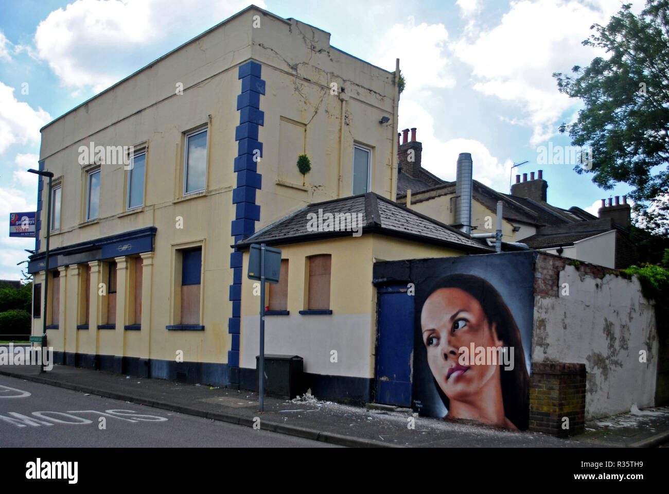 Un arte di strada ritratto di una giovane donna adorna la parete posteriore della chiusura di un locale pubblico in Penge sud di Londra, Regno Unito. Foto Stock