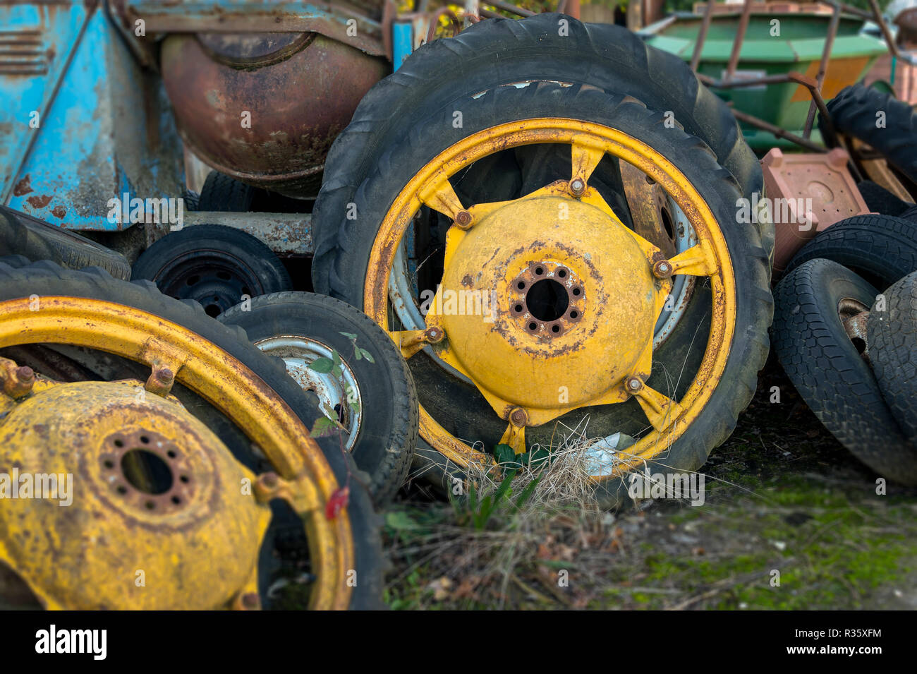 Vecchi pneumatici del trattore in un cantiere di fattoria, dipinto di giallo Foto Stock