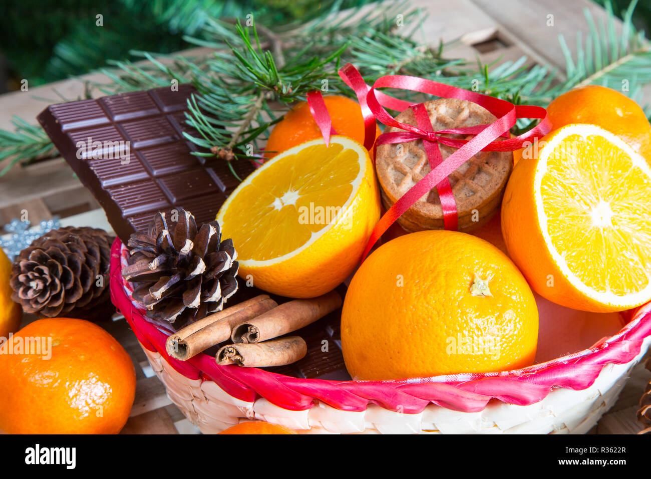 Vacanze di Natale ancora in vita con close up bastoncini di cannella, arance, cioccolato e cono di pino Foto Stock