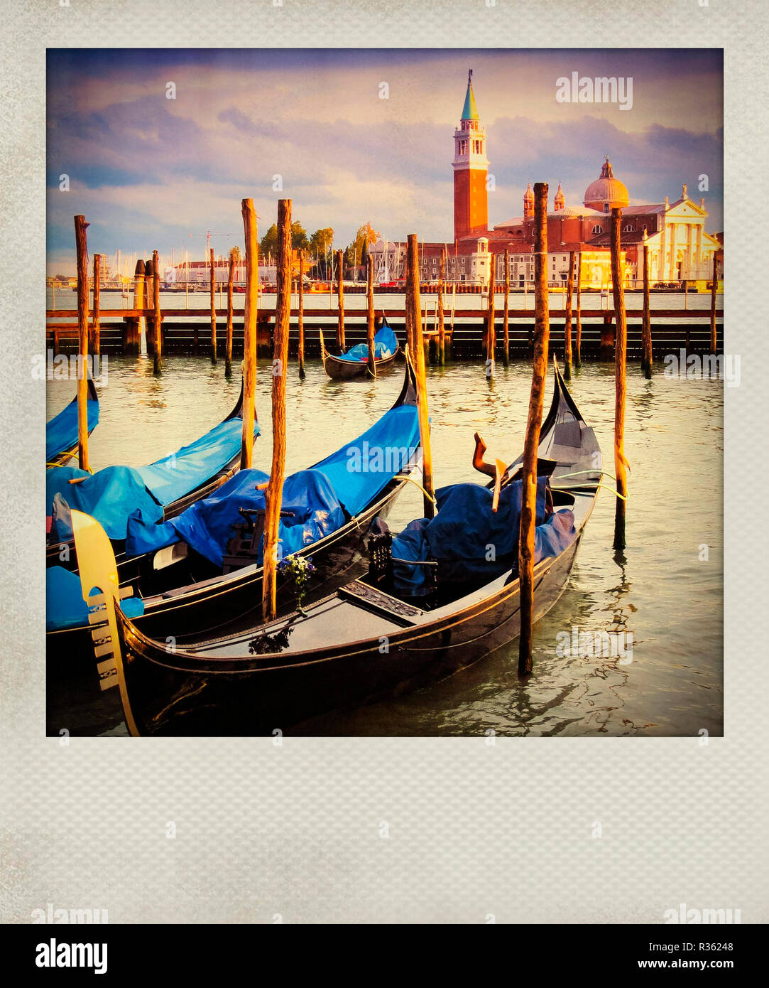 Polaroid vintage. Gondole ancorate al tramonto con edifici storici sullo sfondo a Venezia, Italia Foto Stock