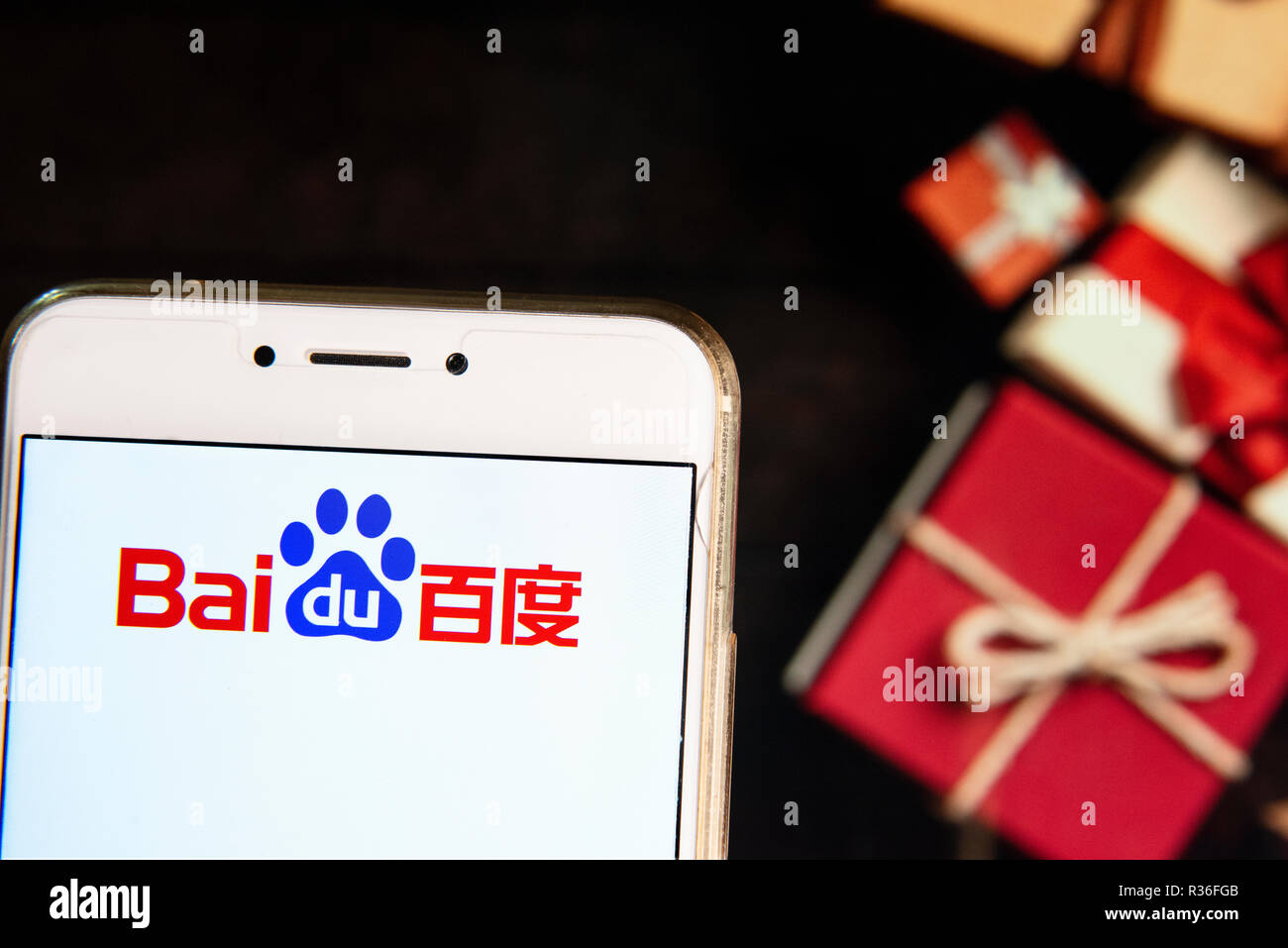 Multinazionale cinese tecnologia azienda Baidu logo è visibile su un androide dispositivo mobile con un Natale regali avvolti in background. Foto Stock