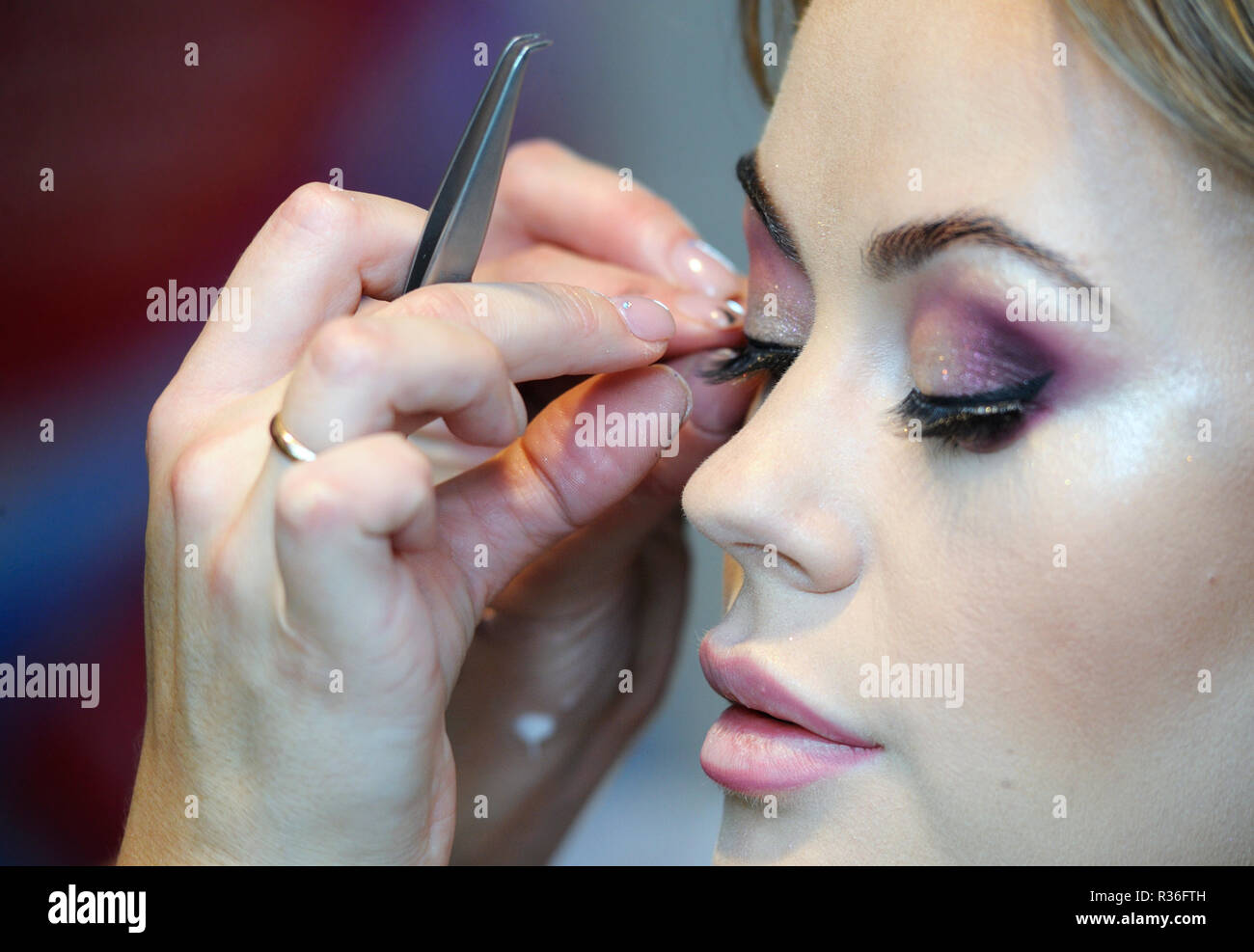 In un salone di bellezza. Make-up artist le dita che fissa ciglia finte su una femmina del cliente ciglia. Kiev, Ucraina. Novembre 8, 2018 Foto Stock