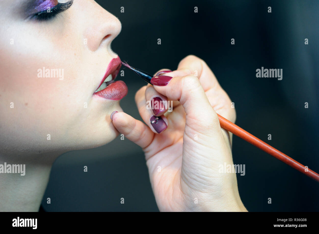 In un salone di bellezza. Make-up artist la mano disegna le labbra i contorni di un volto della ragazza utilizzando una matita cosmetica. Kiev, Ucraina. Novembre 8, 2018 Foto Stock