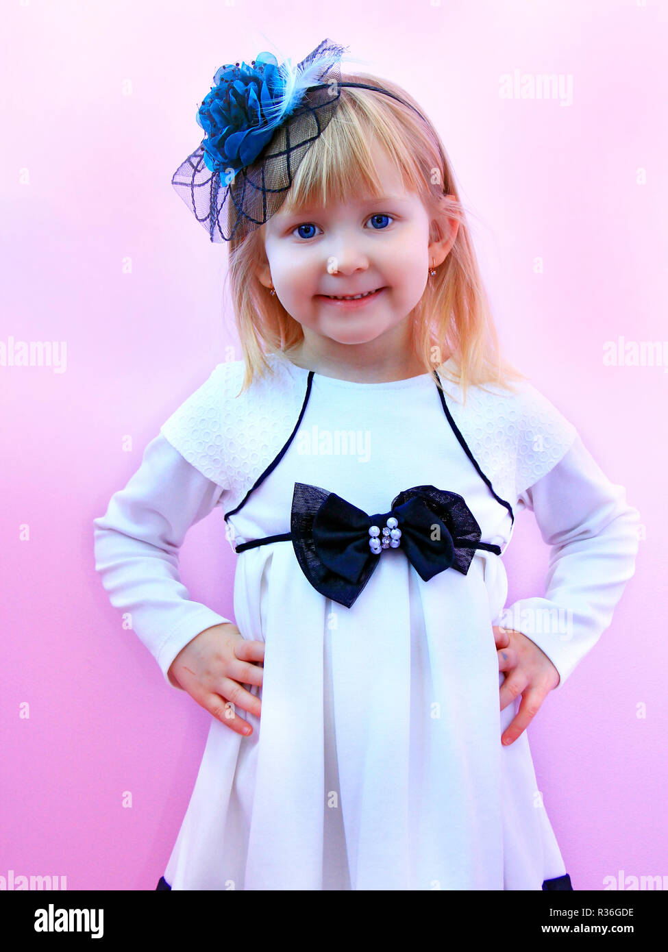 Bambina nel quartiere alla moda di cappello elegante sorridente e posa su  sfondo lilla. Moda Infantile. Il concetto di moda Foto stock - Alamy