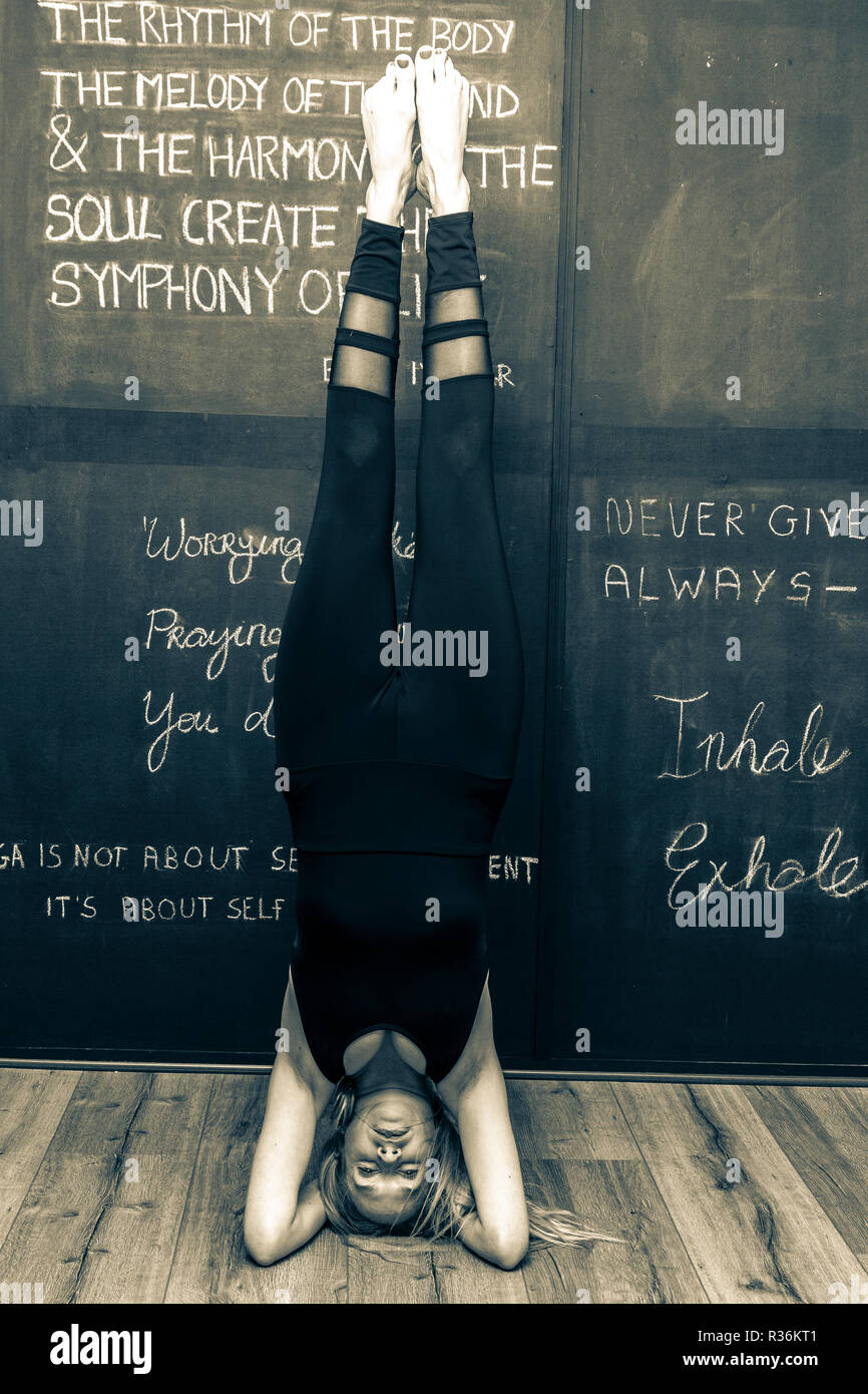 Donna con capelli lunghi biondi facendo esercizi yoga Foto Stock