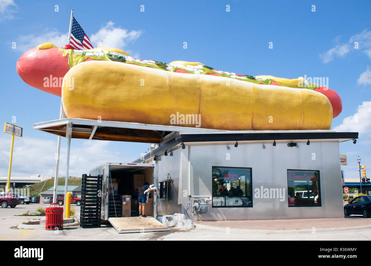 Una gigantesca scultura di hot dog si erge orgogliosamente a Mackinaw City, Michigan, e serve stravaganti a lato della strada con un lato del fascino americano. Foto Stock