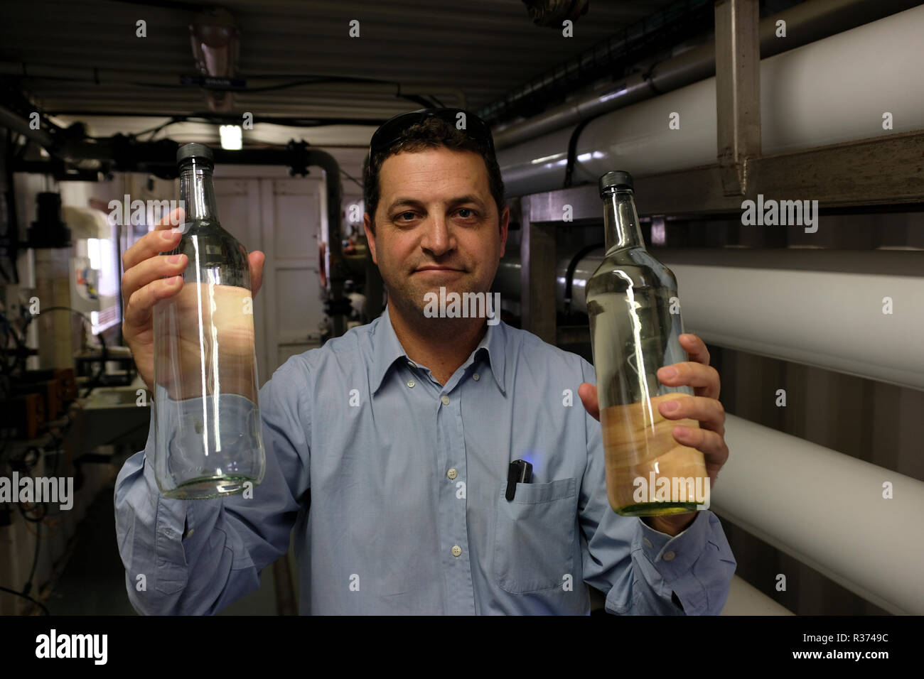 Sivan Bleich di trattamento di acqua di alimentazione e Dep. Manager della società WaTech trattiene le bottiglie di acqua che mostra le fasi di trattamento in corrispondenza di Shafdan impianto di trattamento delle acque reflue, Israele principale di trattamento delle acque reflue stabilimento situato in Rishon LeZionon il 21 novembre 2018. Shafdan tratta delle acque reflue municipali dalla maggiore zona di Tel Aviv, mediante un processo multi-fase che comprende la filtrazione di base e trattamenti biologici chiamato terreno di trattamento della falda acquifera (SAT) per creare il riutilizzo della qualità di acque reflue, che viene utilizzato per l'irrigazione in Israele. Il paese soddisfi oltre l'80% delle sue esigenze di irrigazione da liquami trattati l'acqua. Foto Stock