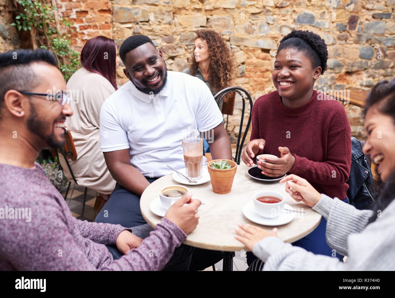 Gli amici più di parlare di caffè in un elegante cortile cafe Foto Stock