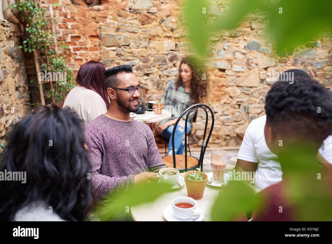 Amici in chat insieme in un caffè in un bar alla moda cortile Foto Stock