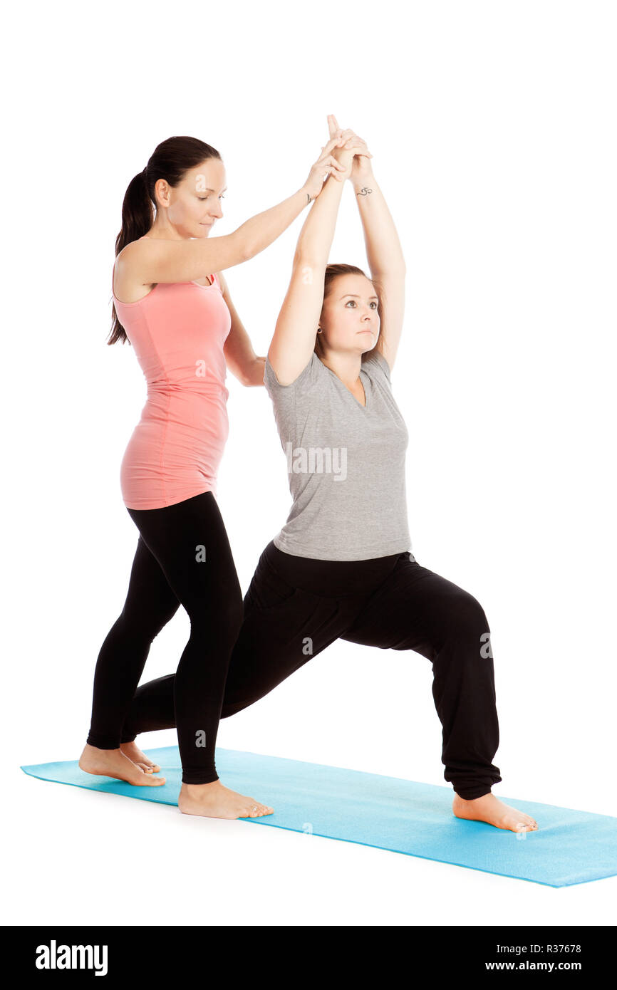 Insegnante di yoga fornisce assistenza durante il training virabhadrasana Foto Stock